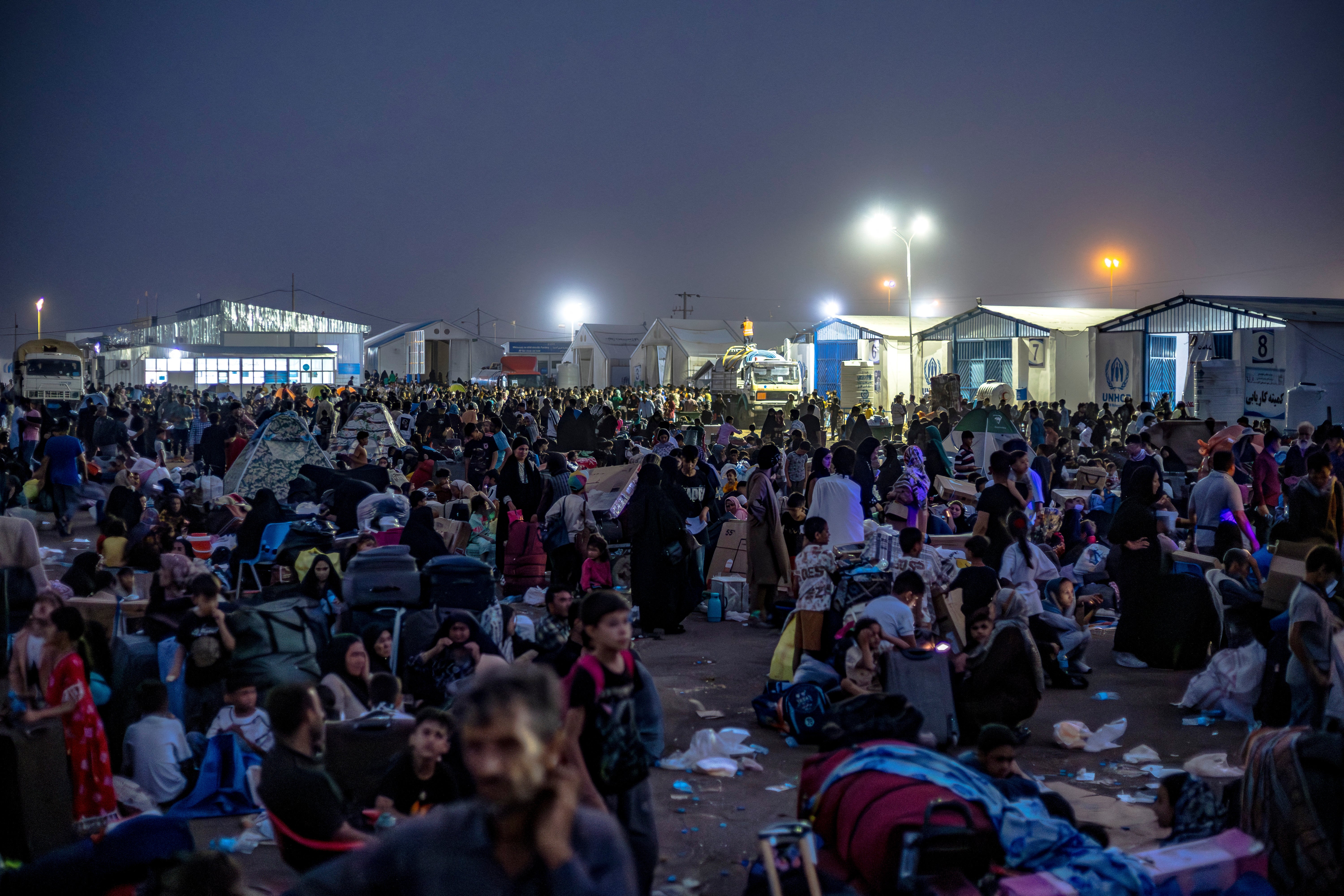 Afghan refugees, after being deported from Iran, rest at the Islam Qala border crossing between Afghanistan and Iran