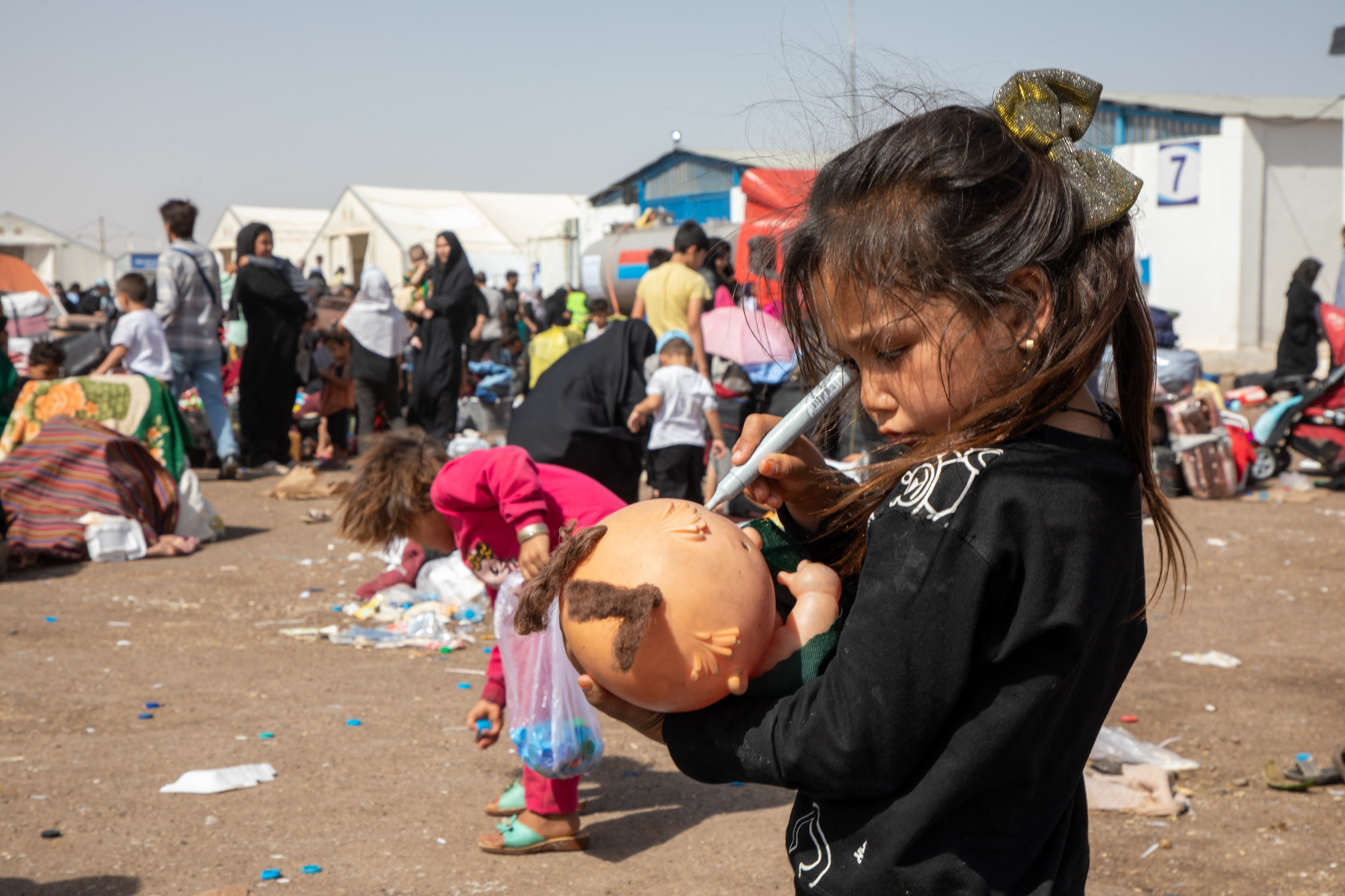 A young girl holds a broken doll amid newly arrived Afghan returnees at Islam Qala border crossing