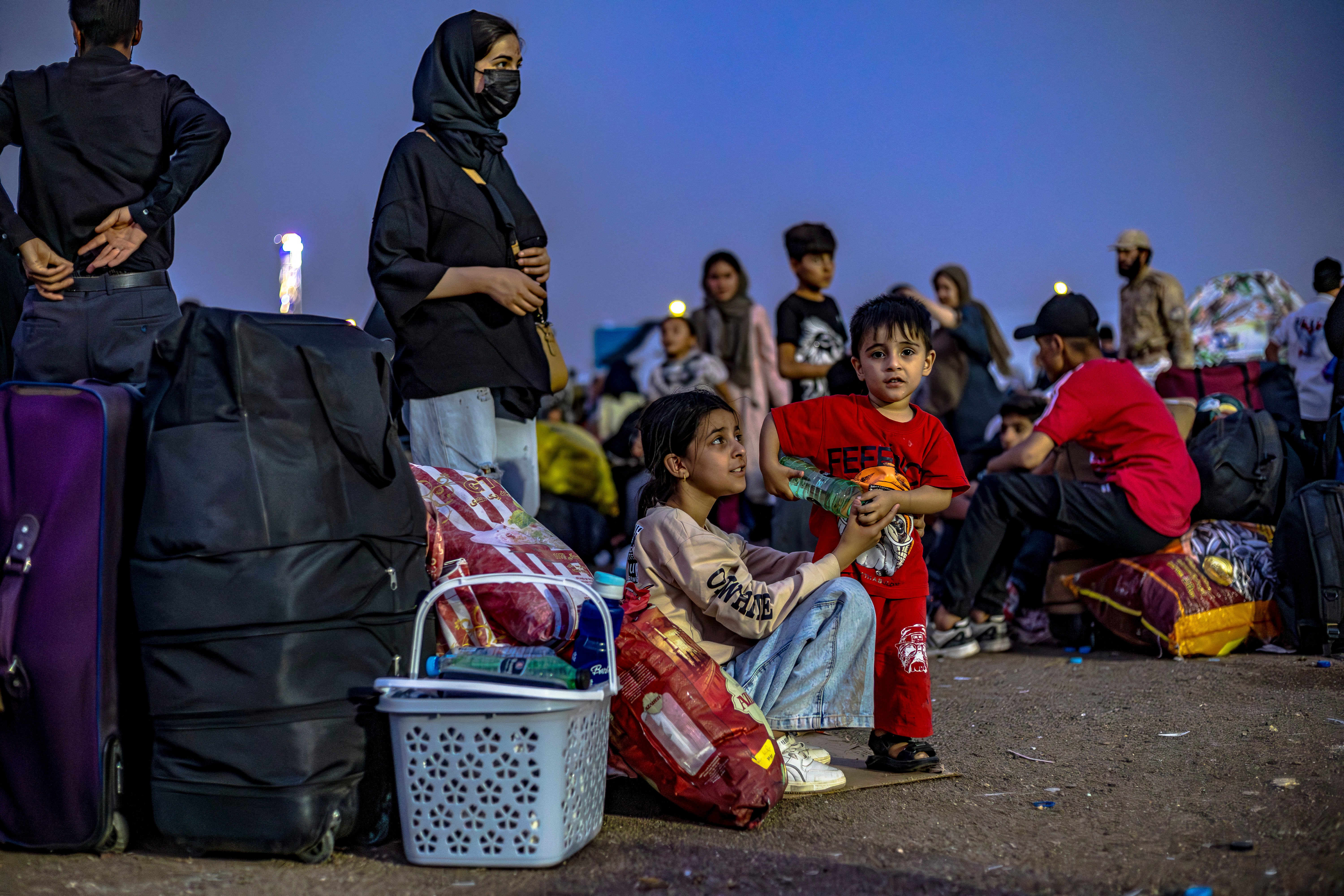 Afghan refugees, after being deported from Iran, rest at the Islam Qala border crossing between Afghanistan and Iran