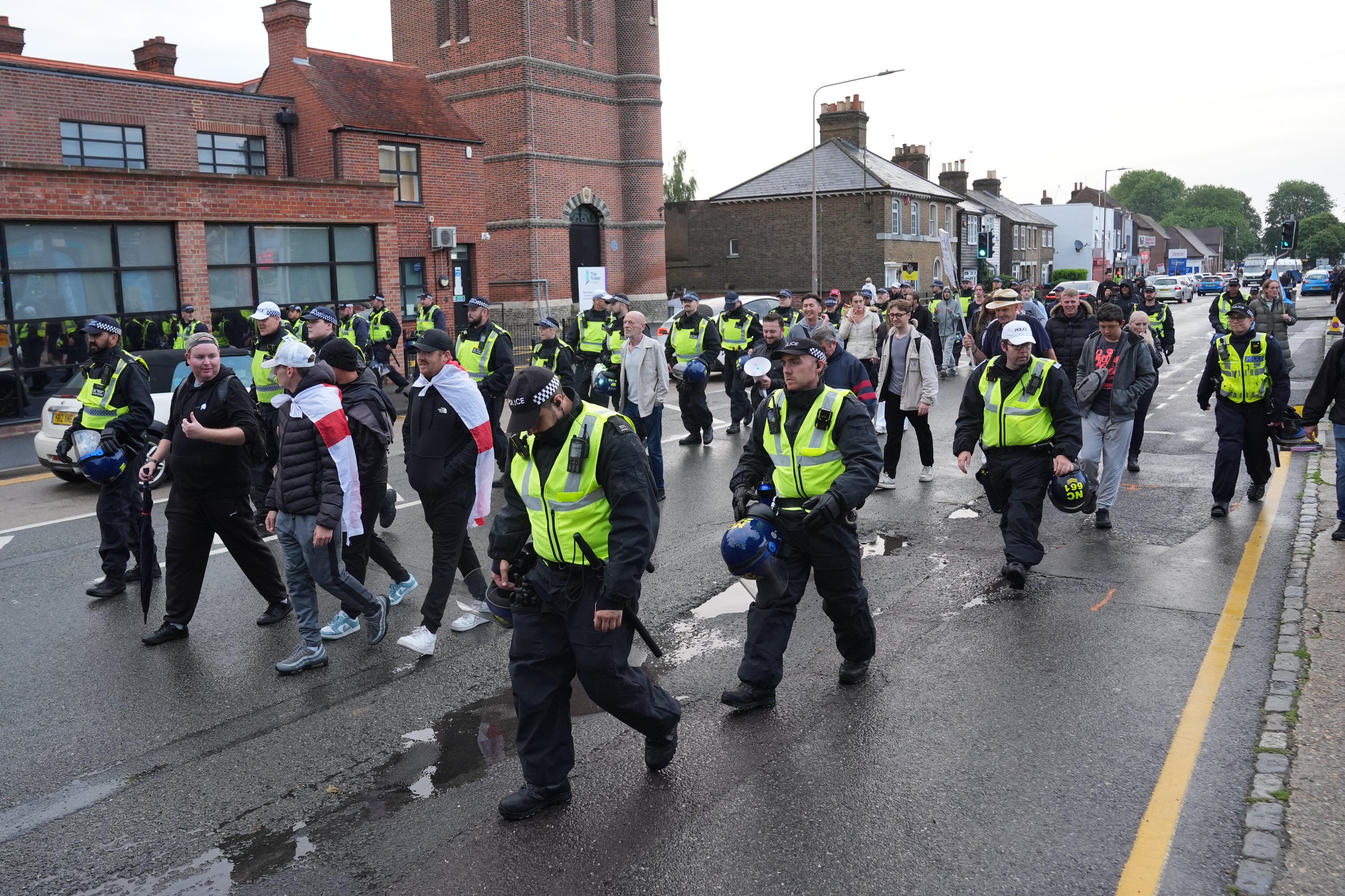 Police walk next to protesters in Epping (Lucy North/PA)