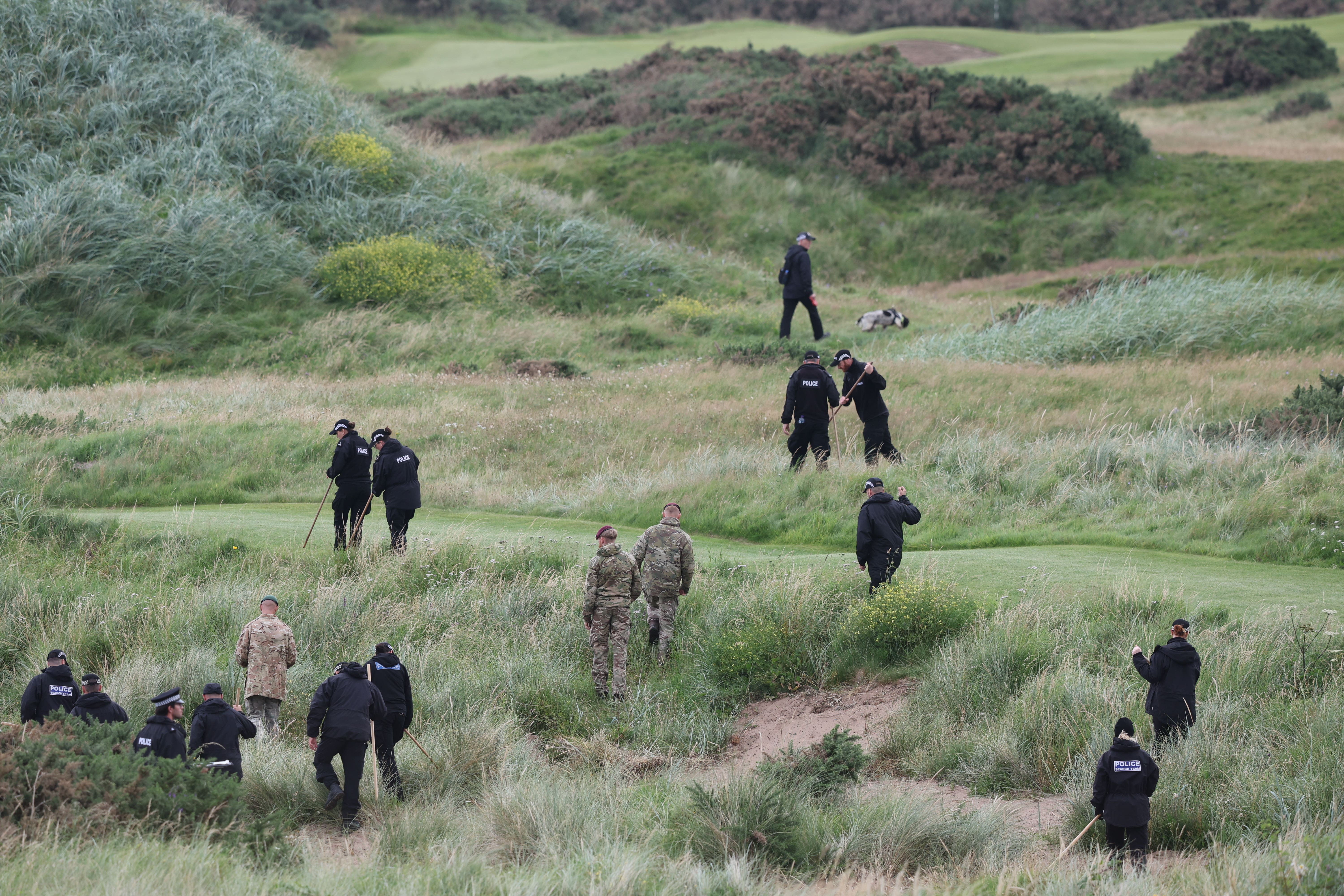 Police officers and military personnel search the area around the Trump Turnberry golf resort on the first full day of President Donald Trump’s visit (Robert Perry/PA)