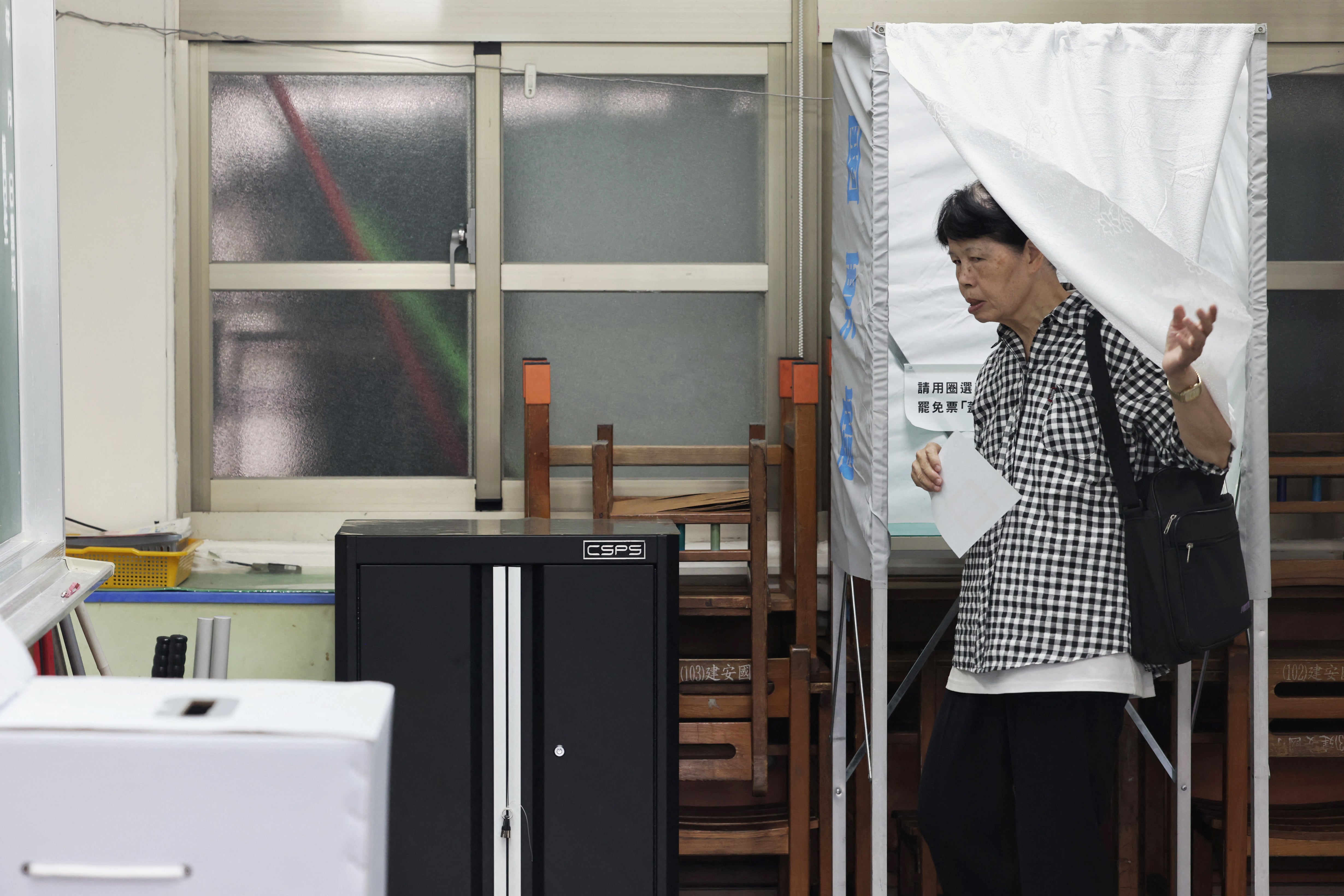 A voter leaves a booth during voting for the recall election at a polling station in Taipei on July 26, 2025