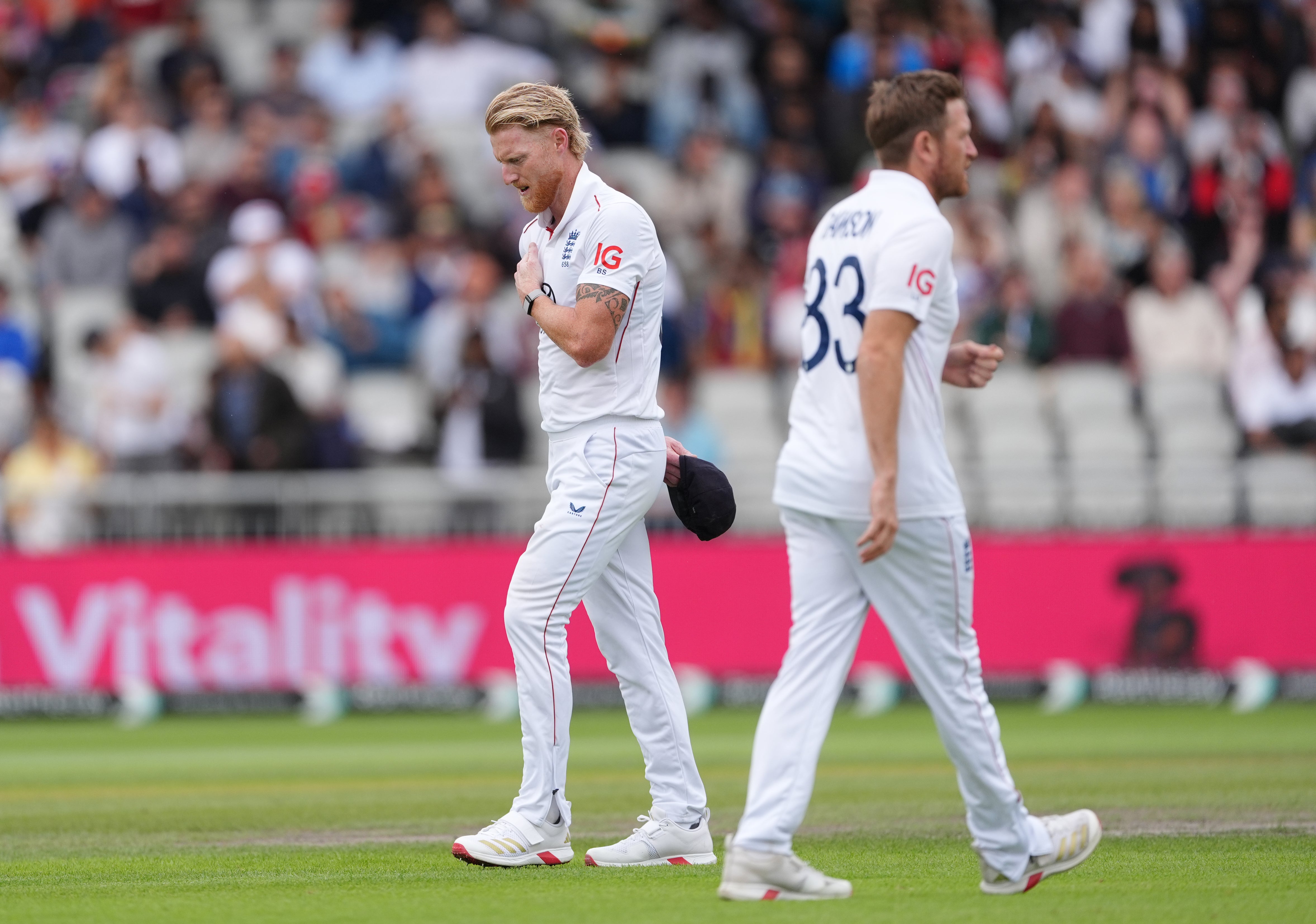 England captain Ben Stokes, left, rubs his shoulder after bowling in Manchester