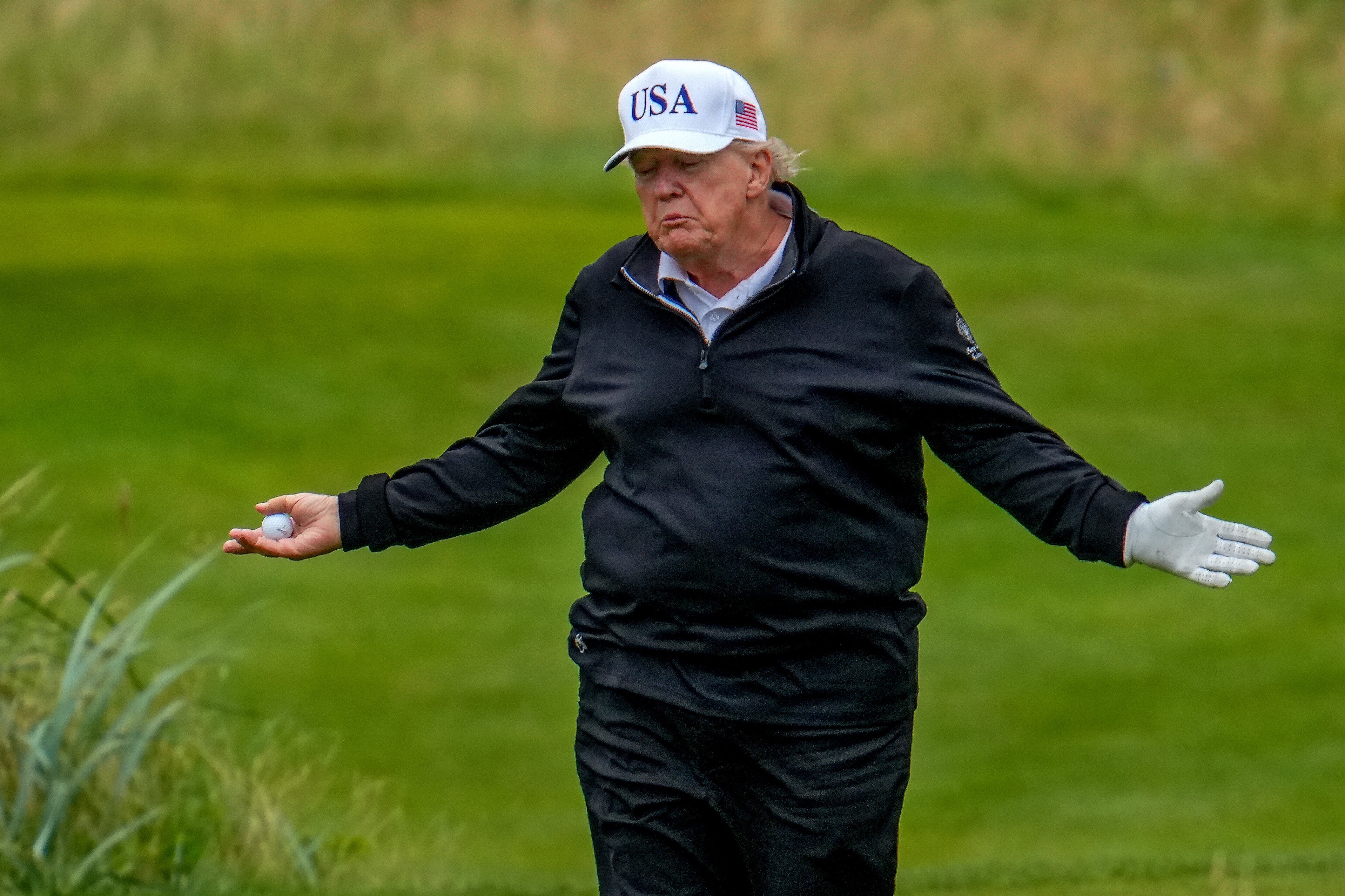 US President Donald Trump reacts as he plays a round of golf at Trump Turnberry golf course during his visit to the UK on July 27, 2025 in Turnberry, Scotland