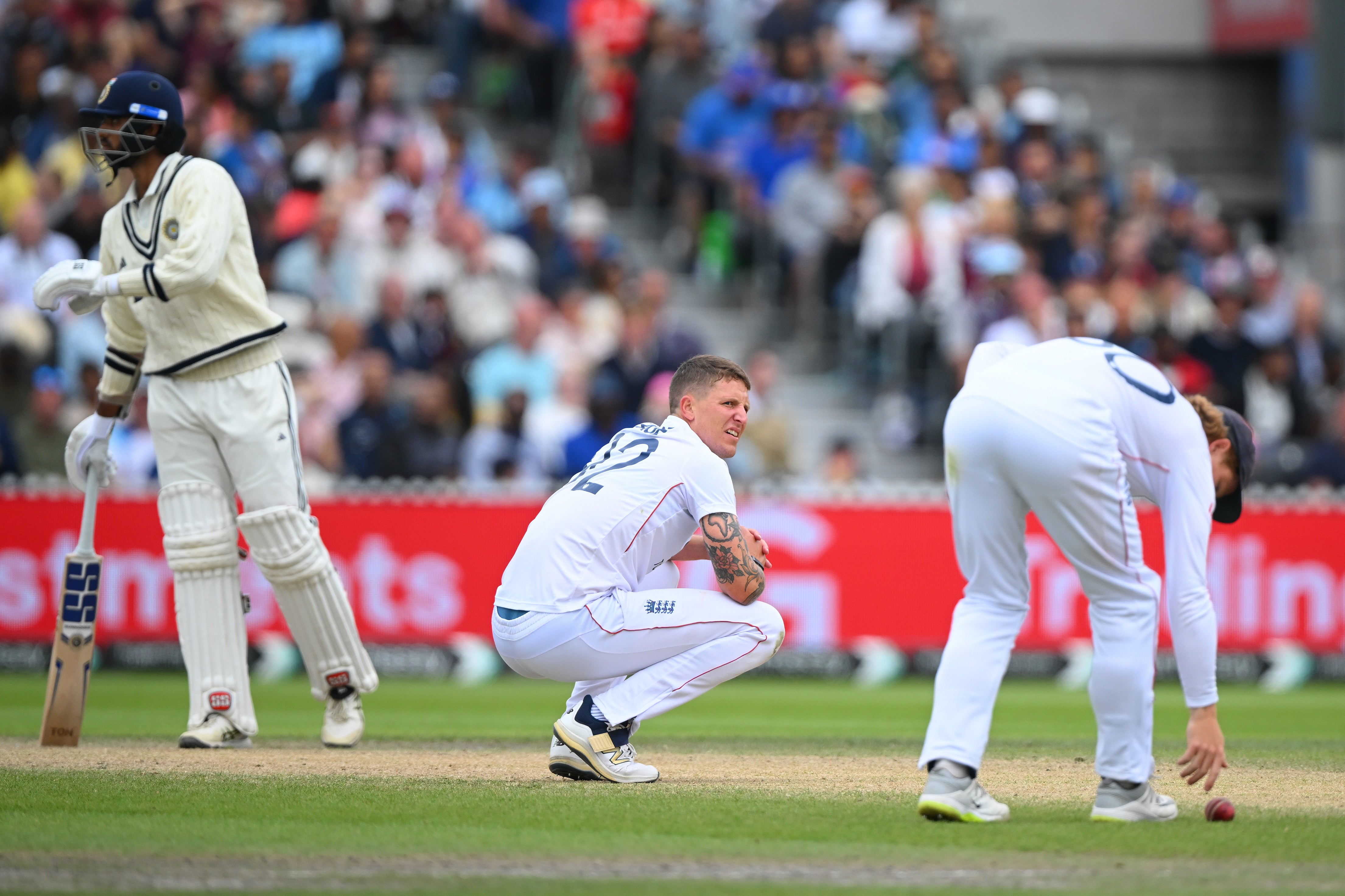 Brydon Carse of England gets down on his haunches as Ollie Pope retrieves the ball on the last day