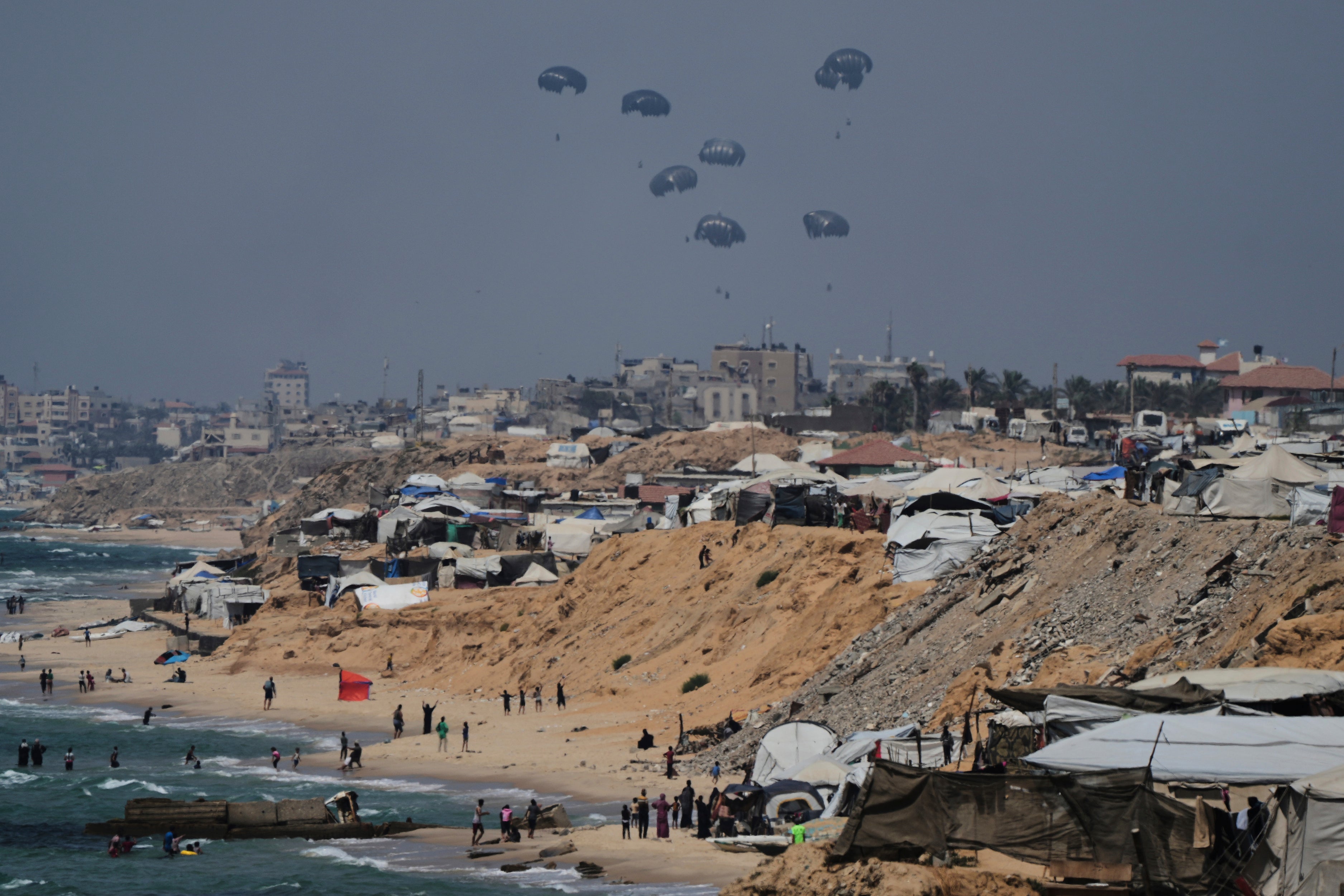 Humanitarian aid is airdropped to Palestinians over the central Gaza Strip as seen from Khan Younis (Abdel Kareem Hana/AP photo)