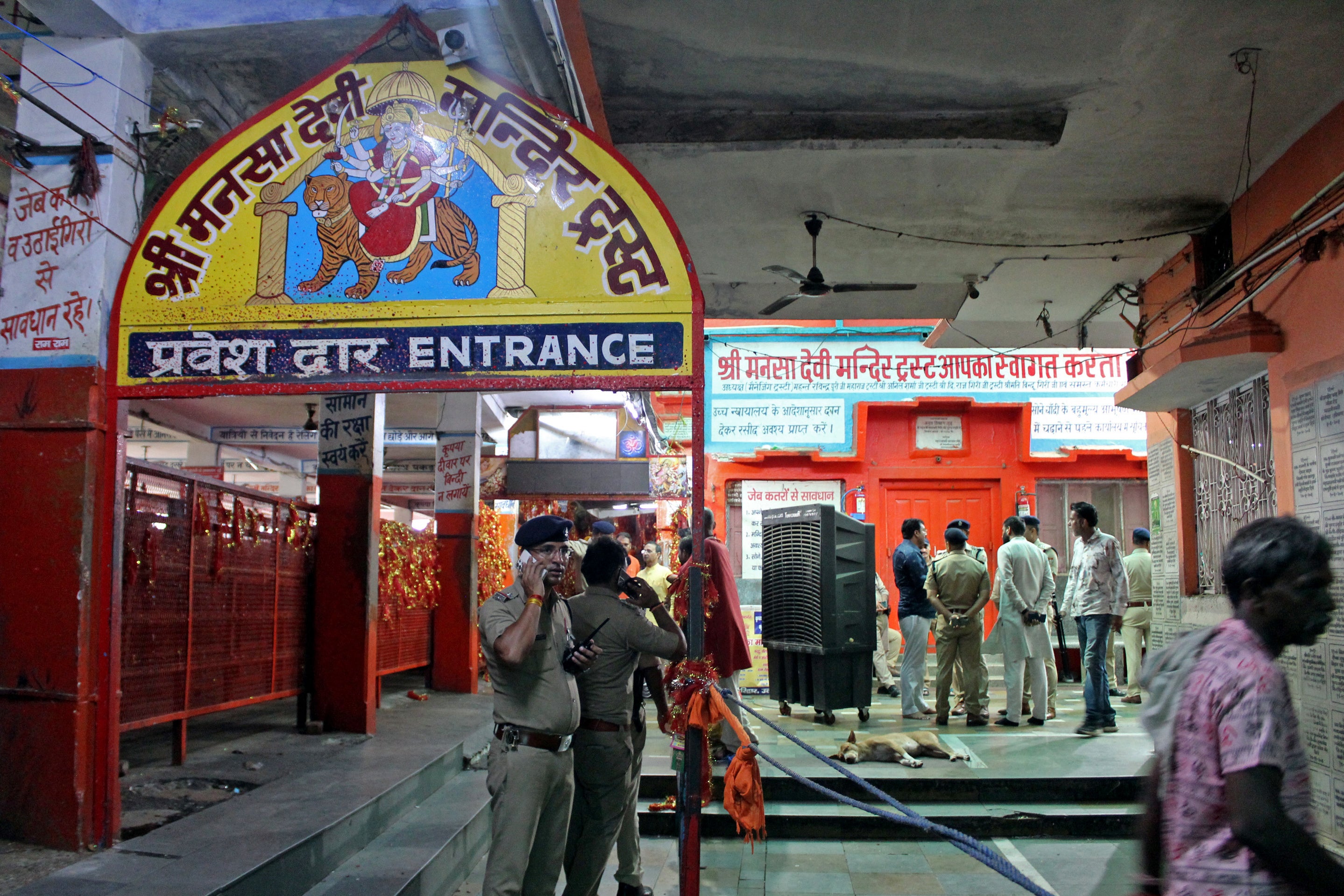 Police officials stand guard near the site of a stampede at the Mansa Devi temple in Haridwar in Uttarakhand