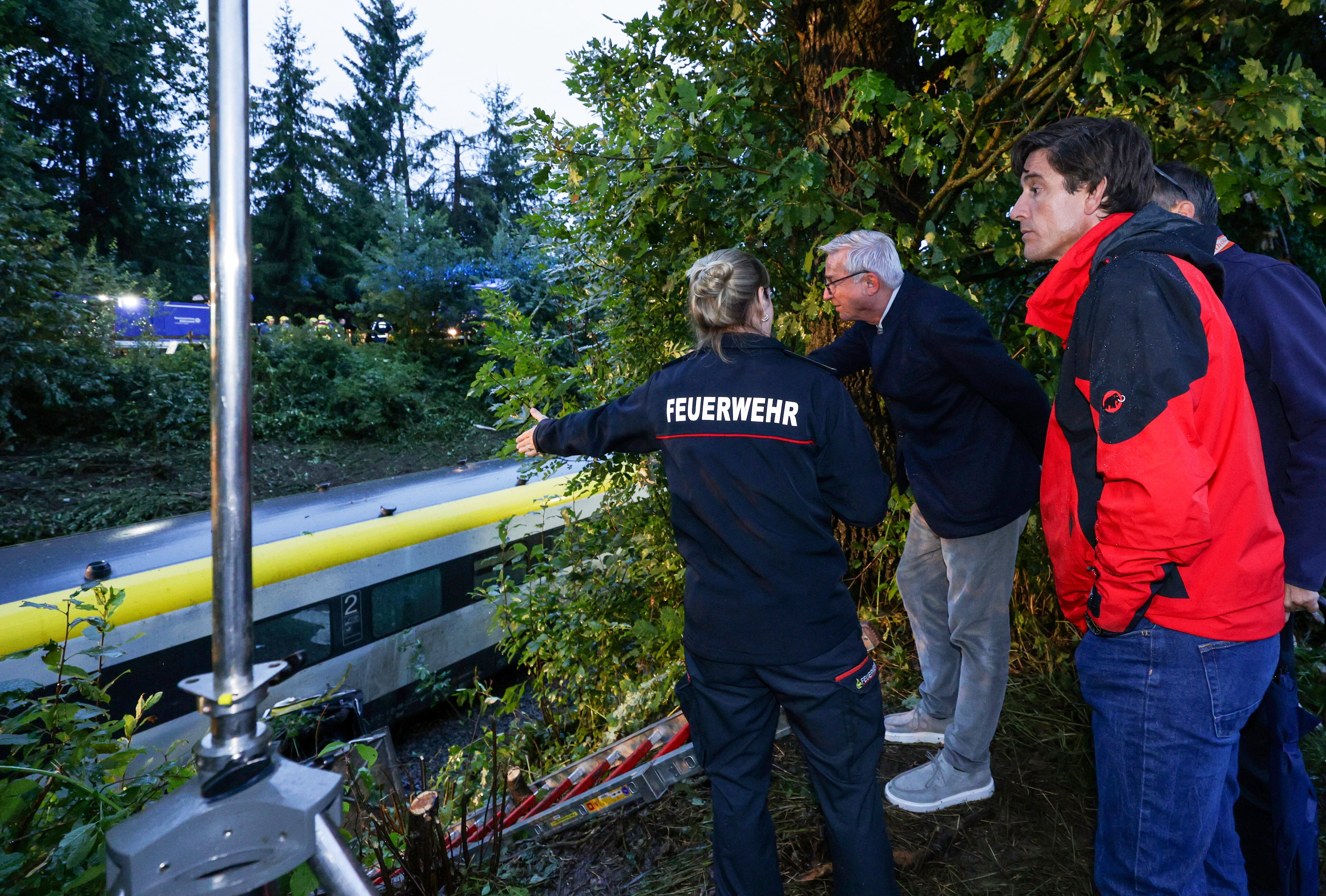District fire chief of the Biberach district, Charlotte Ziller, left, shows the district administrator of the Biberach district, Mario Glaser, and Interior Minister Thomas Strobel, center, the scene of the derailed regional passenger train accident near Riedlingen