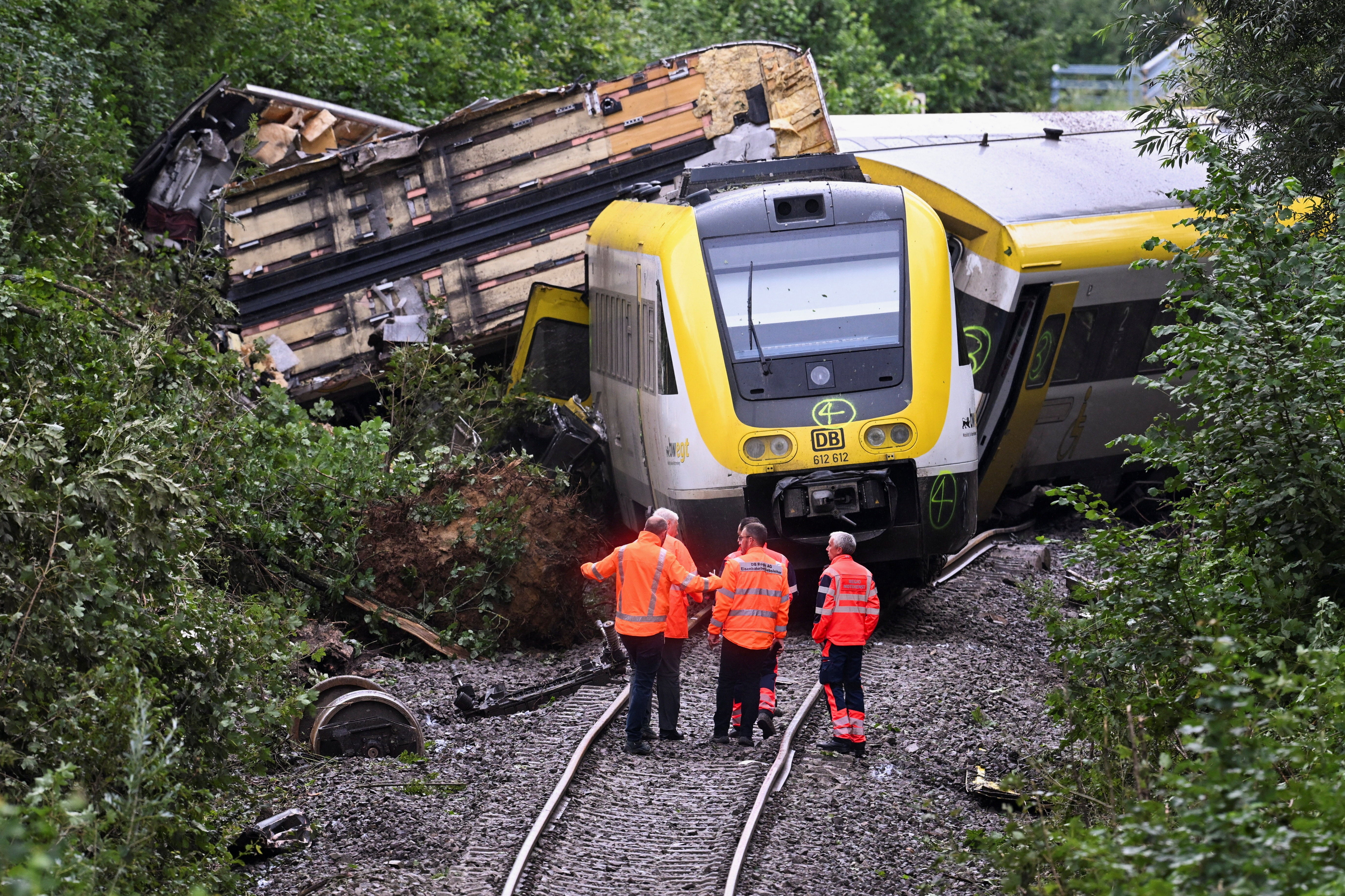 Members of the German Railways Deutsche Bahn stand at the site where a local passenger train derailed causing several casualties, in Riedlingen near Biberach