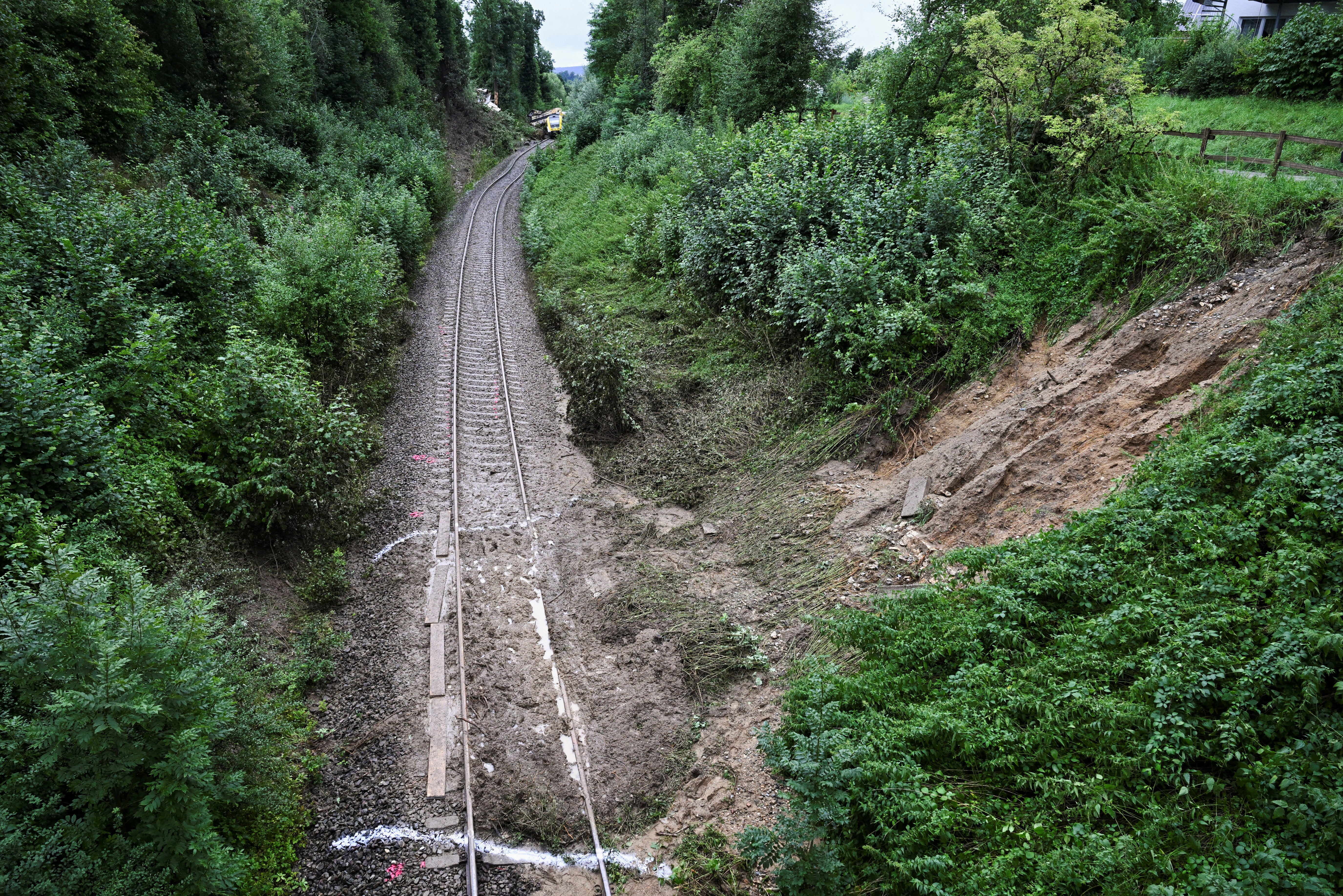 Mud from a landslide lies on the track near the site where a local passenger train derailed causing several casualties