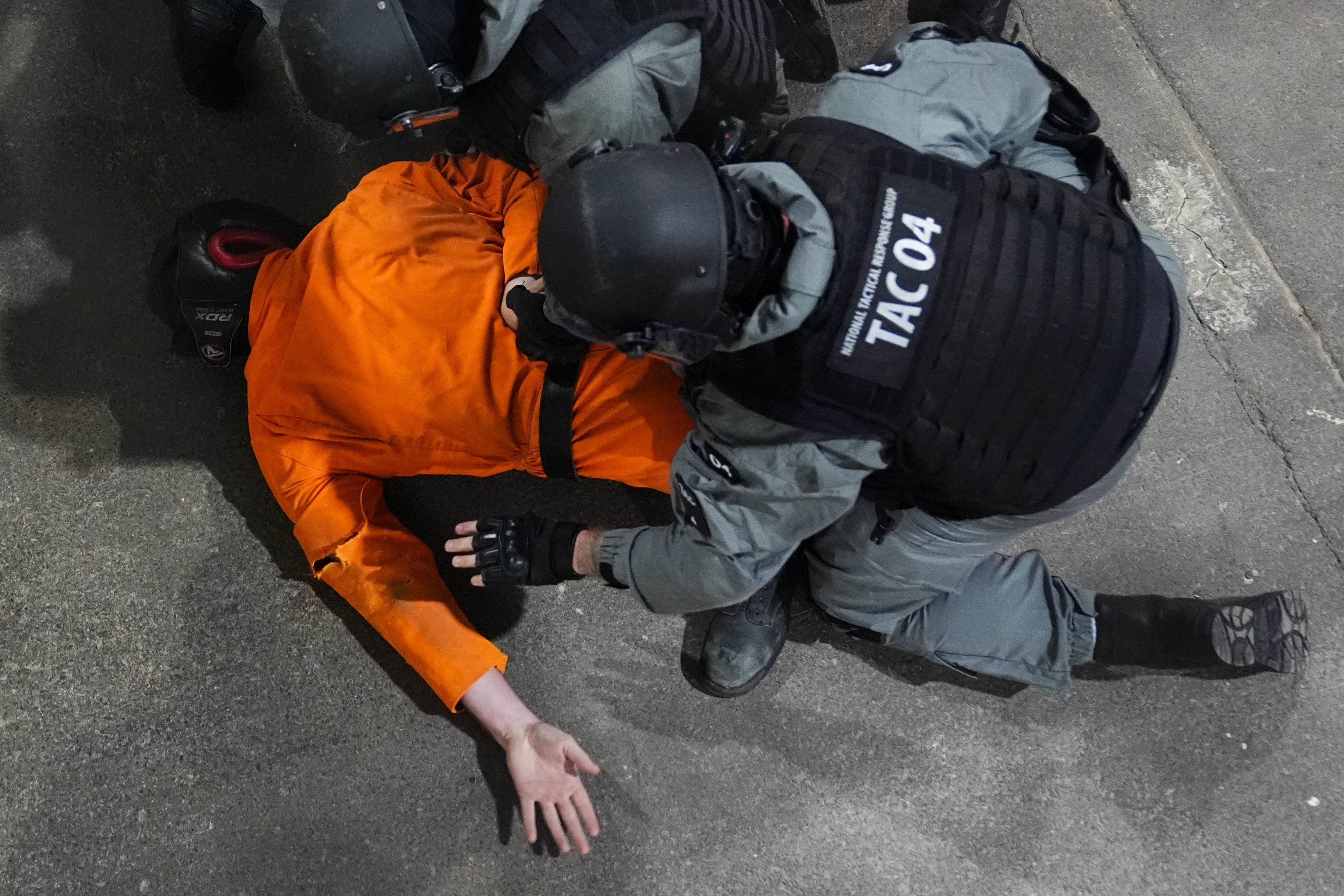 Officers restrain a prisoner during a demonstration showing potential high-risk scenarios for prison officers