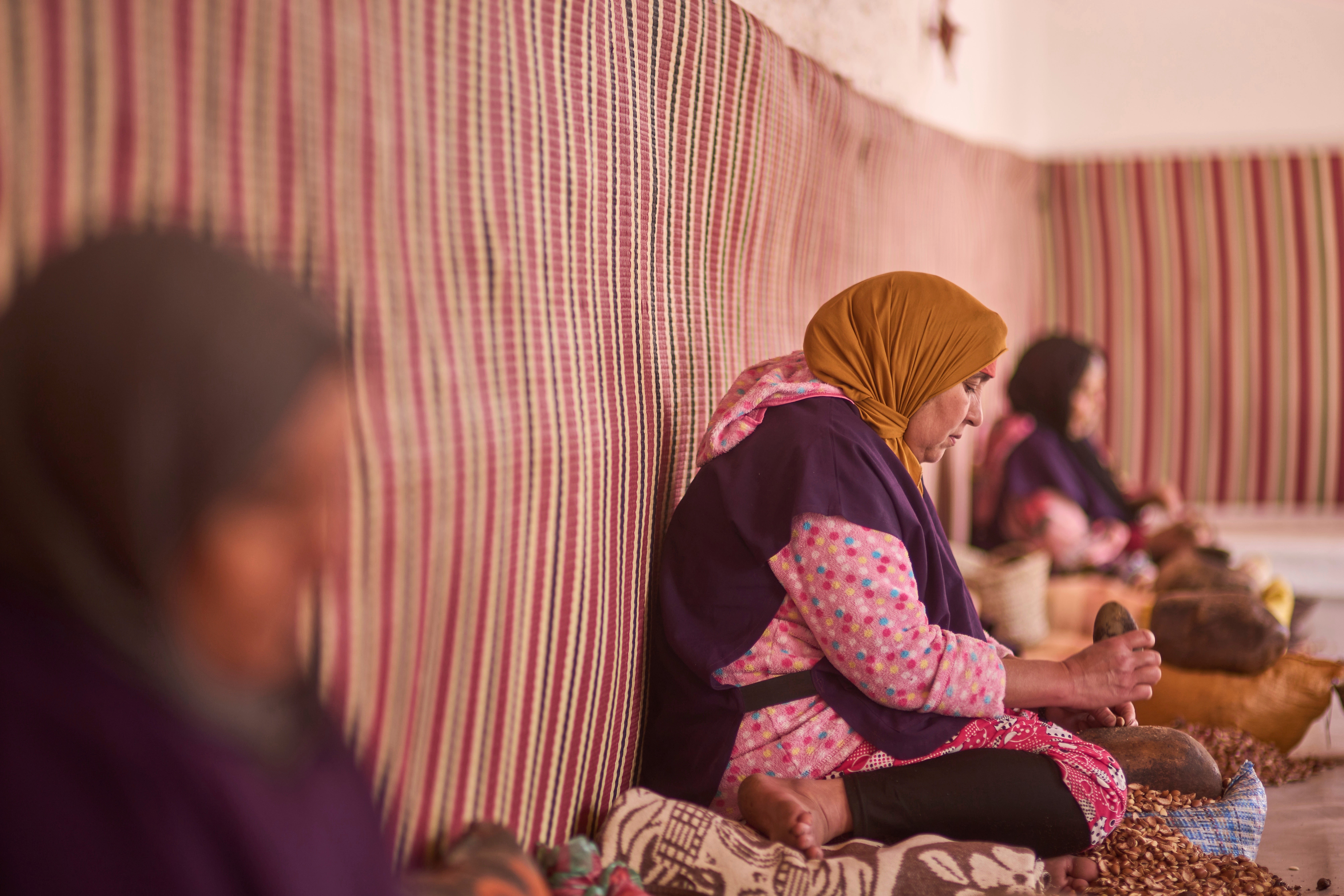 Women crack argan nuts at a cooperative that extracts and produces argan oil and products, in Essaouira, Morocco