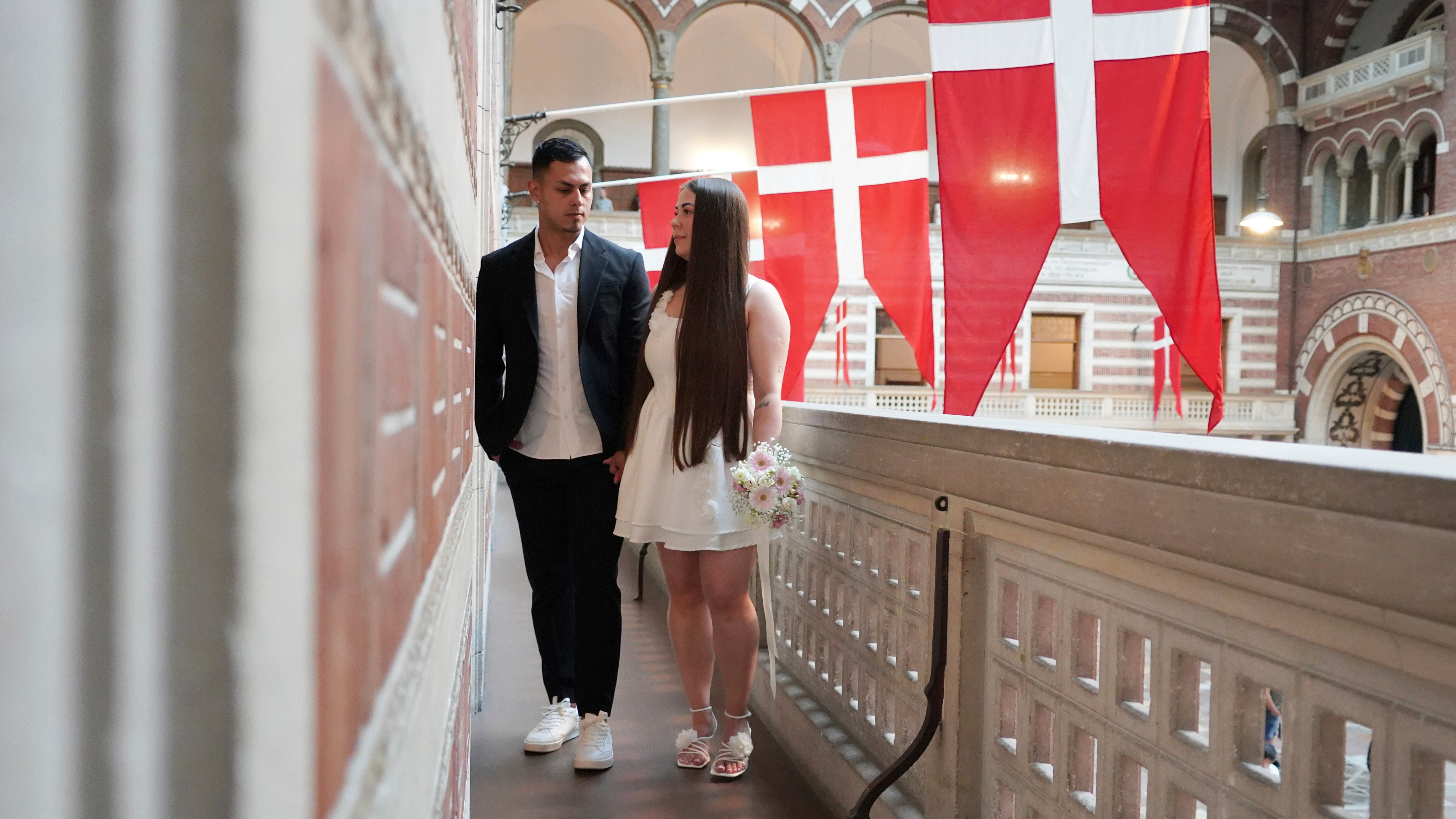 Newlyweds Magdalena Kujawińska, right, from Poland and Heinner Valenzuela from Colombia pose for photos at the Copenhagen City Hall in Copenhagen, Denmark