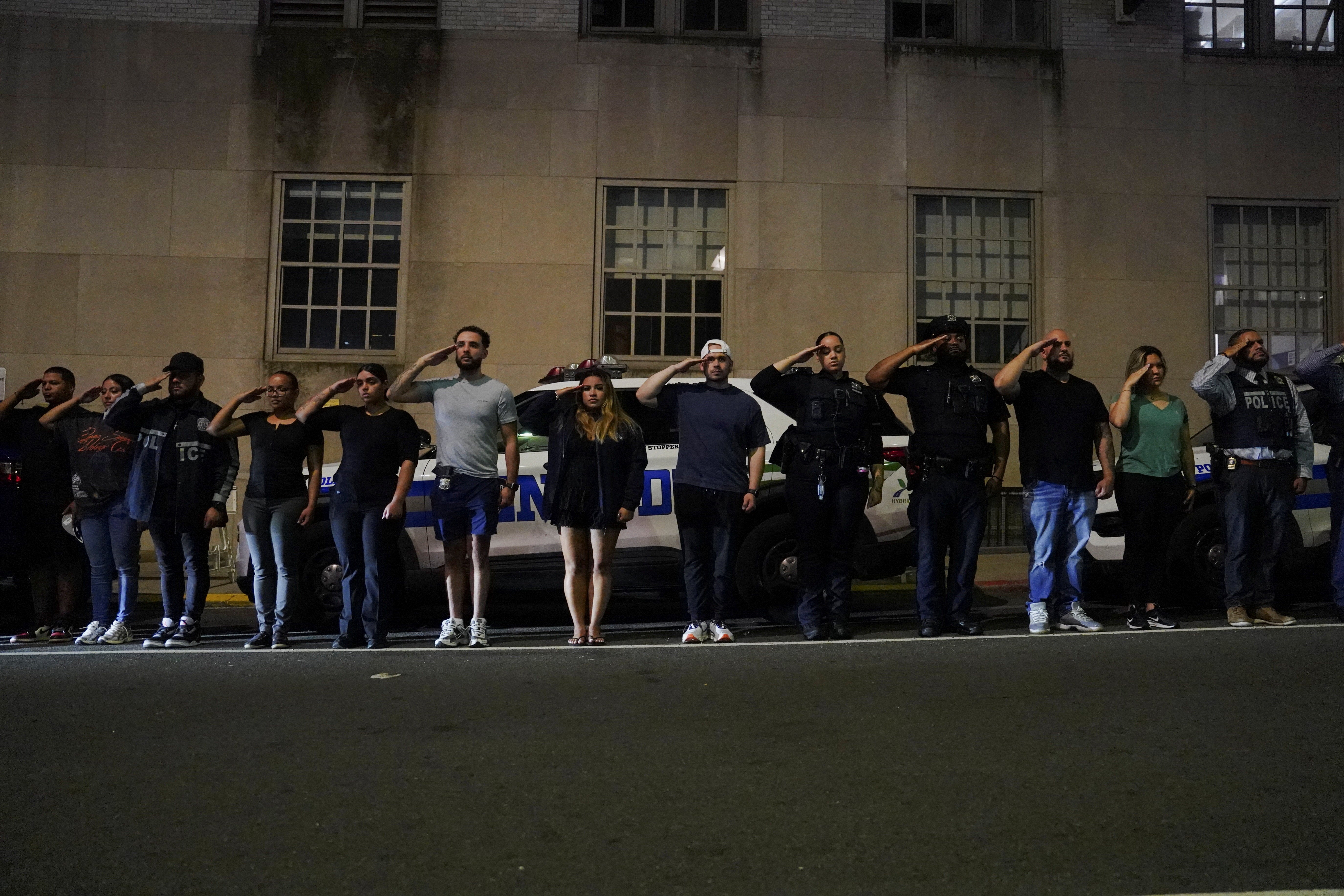 NYPD officers lined the street and saluted the fallen officer as the ambulance transferred him to the hospital.