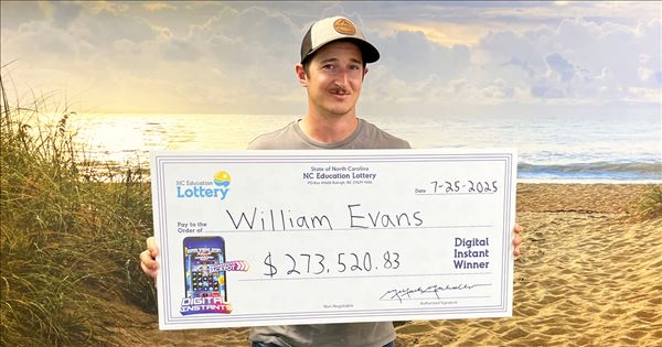 William Evans holding his check after winning $273,520 in a digital lottery game