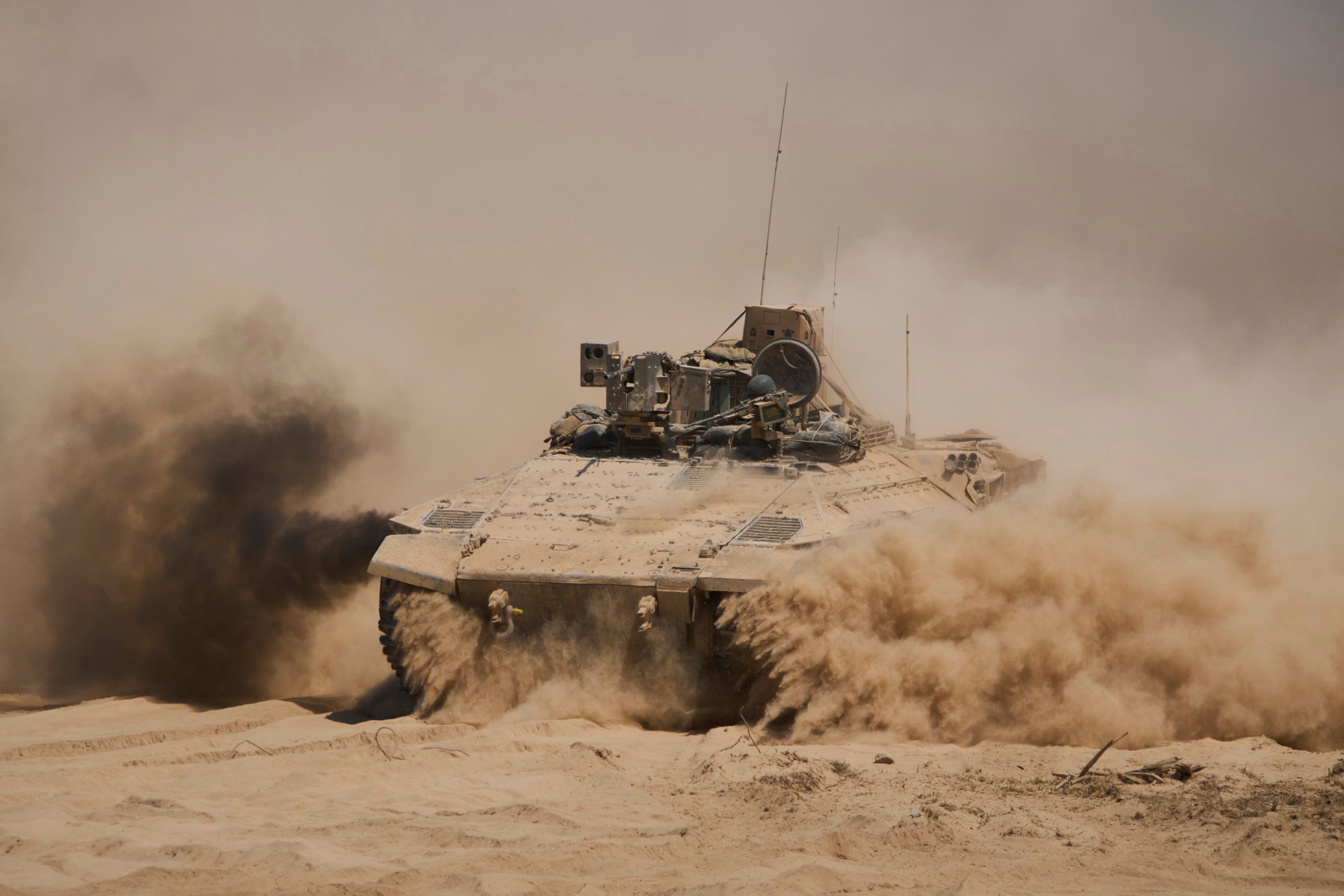 Israeli soldiers drive an armored personnel carrier back from inside the northern Gaza Strip into southern Israel