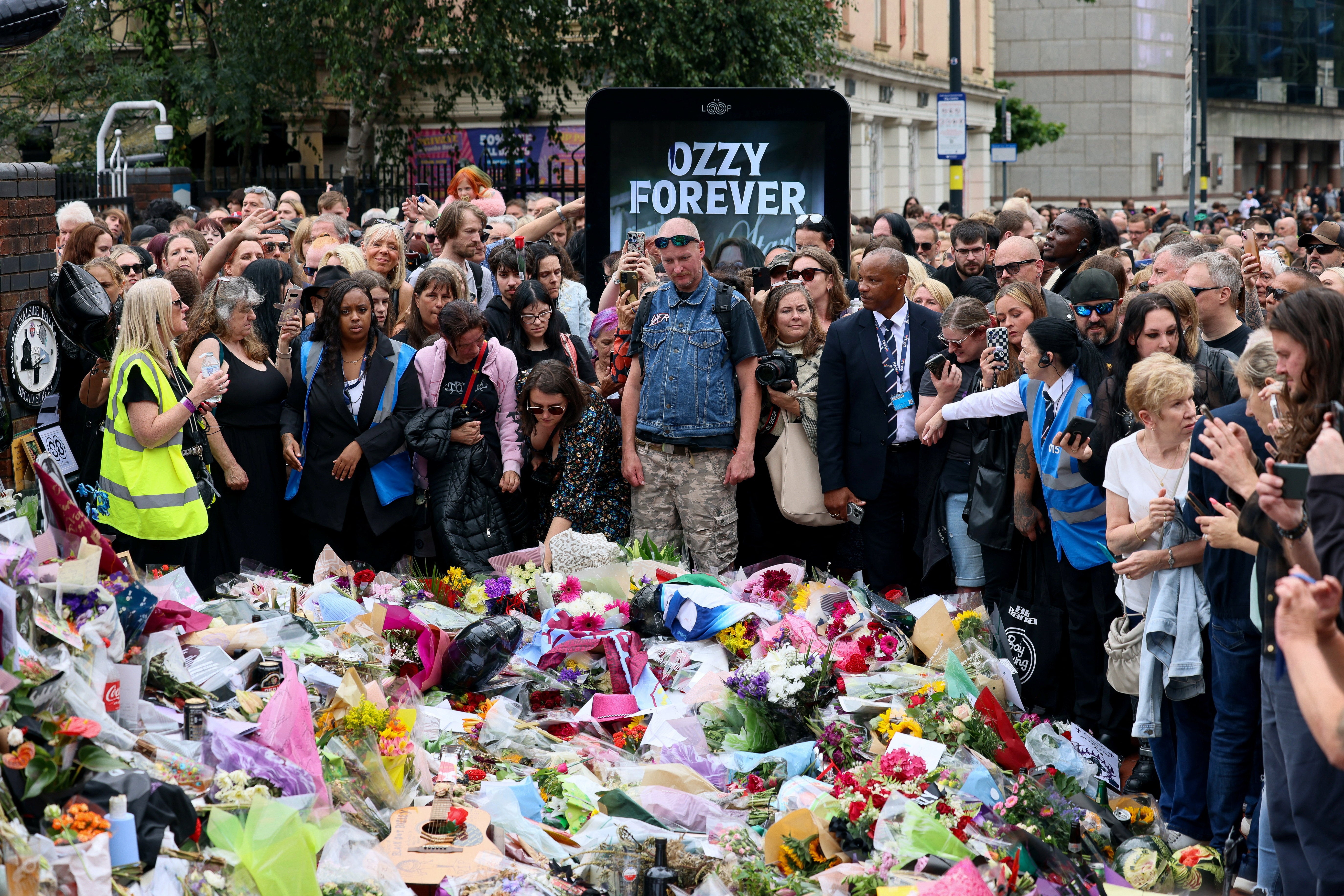 Fans gather around tributes placed at the Black Sabbath Bridge in Birmingham
