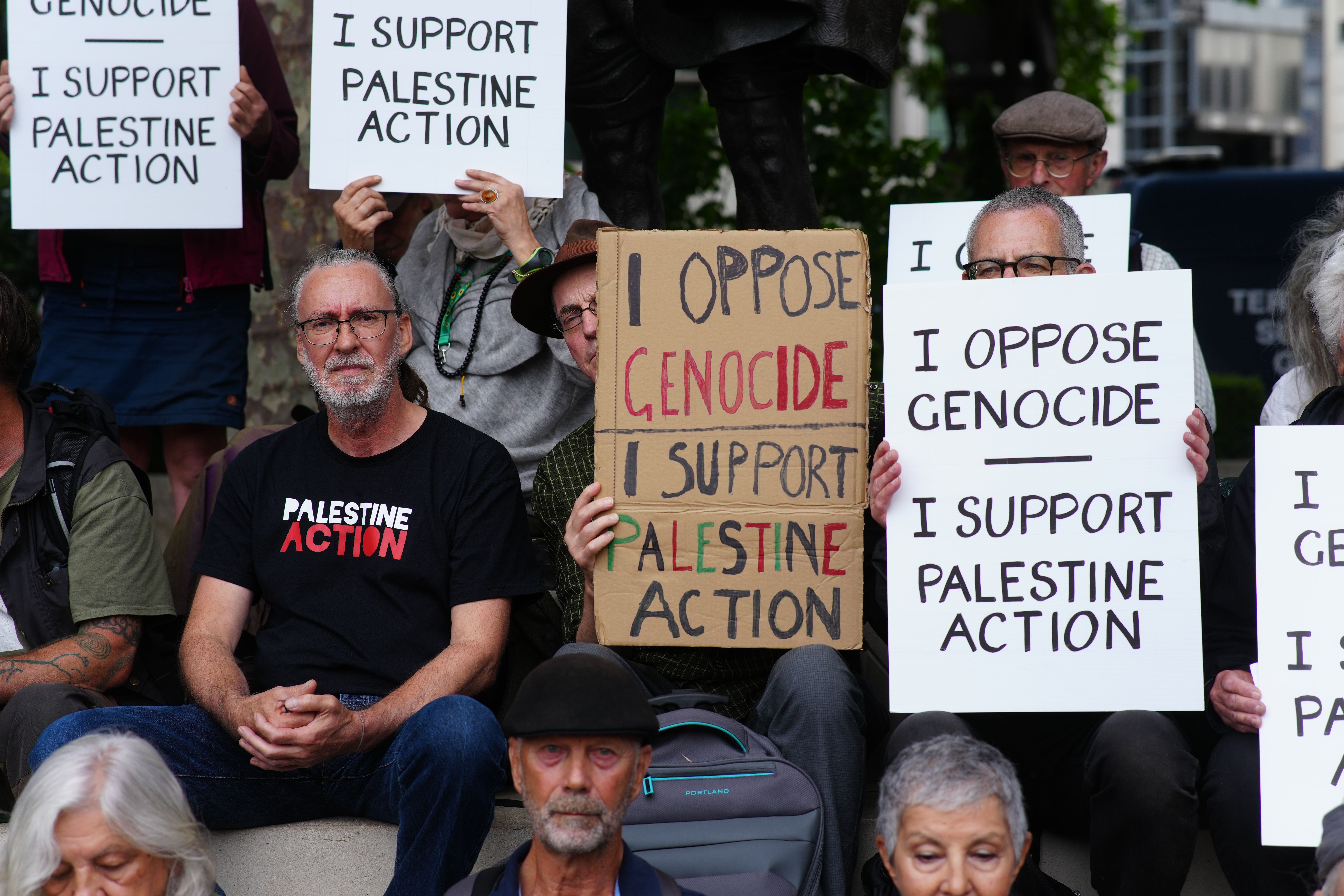 People take part in a protest in support of Palestine Action, organised by the Defend Our Juries group, in front of the Mahatma Gandhi statue in Parliament Square (PA)