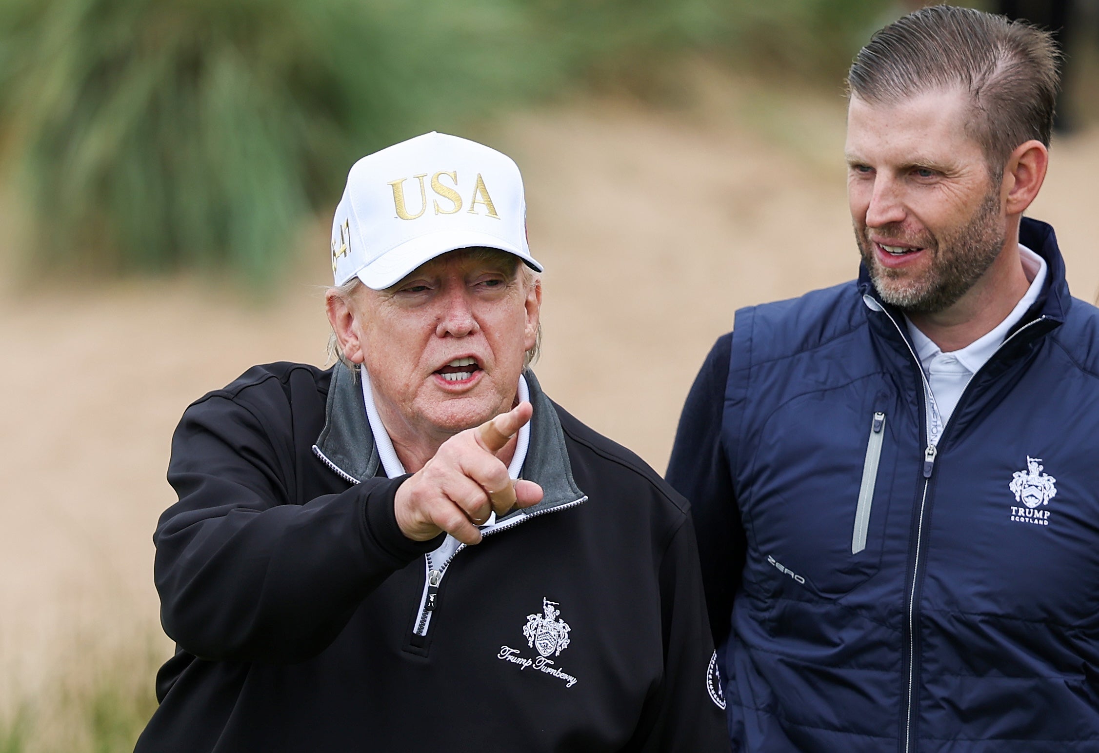 President Donald Trump stands next to Eric Trump at the ribbon-cutting ceremony at a new 18-hole course at Trump International Golf Links on July 29, 2025 in Balmedie, near Aberdeen, Scotland