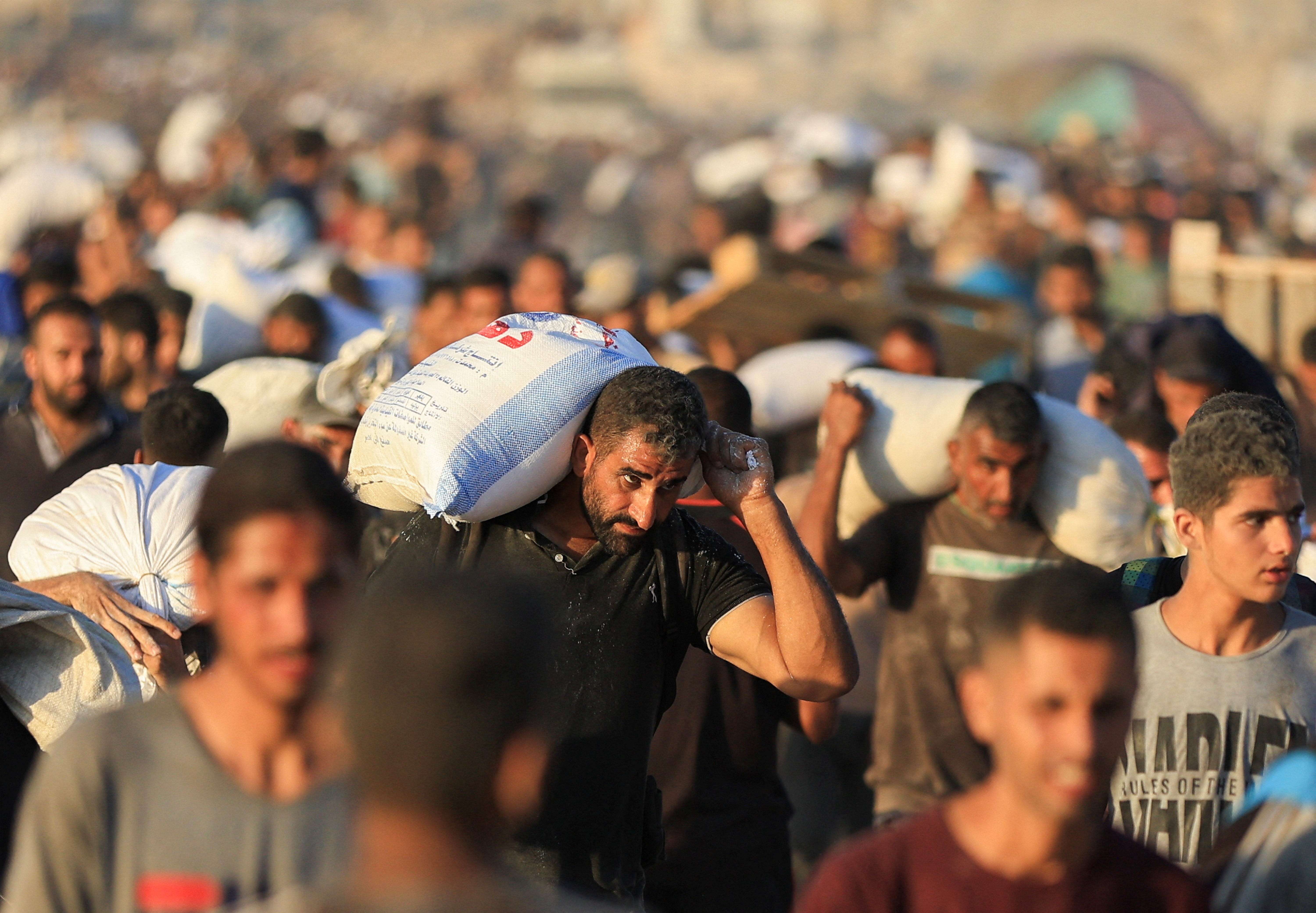 Palestinians carry aid supplies that entered Gaza through Israel