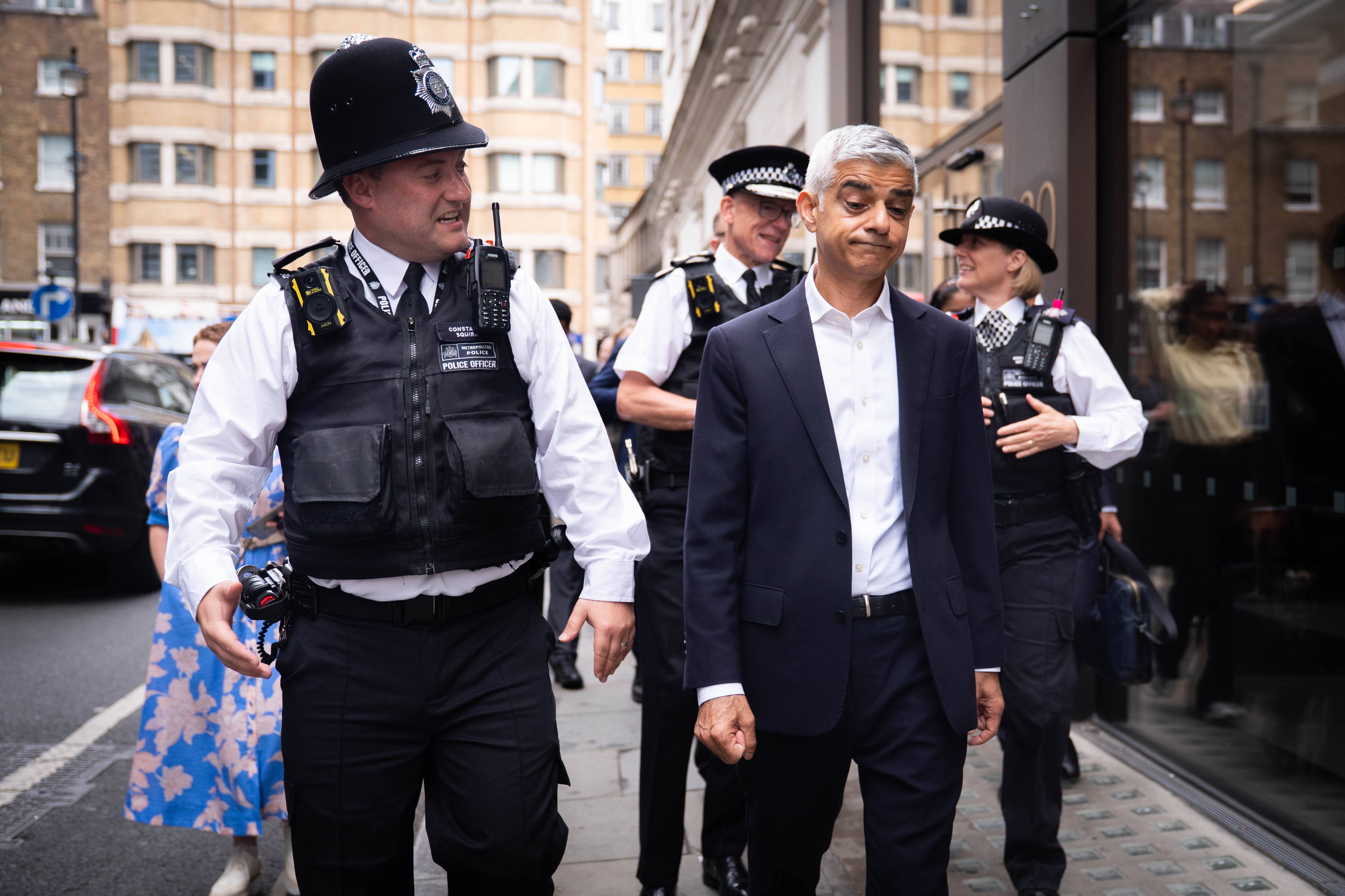 Mayor of London Sir Sadiq Khan speaks with police officers during a walkabout in the West End of London alongside Metropolitan Police Commissioner Sir Mark Rowley (centre, back)