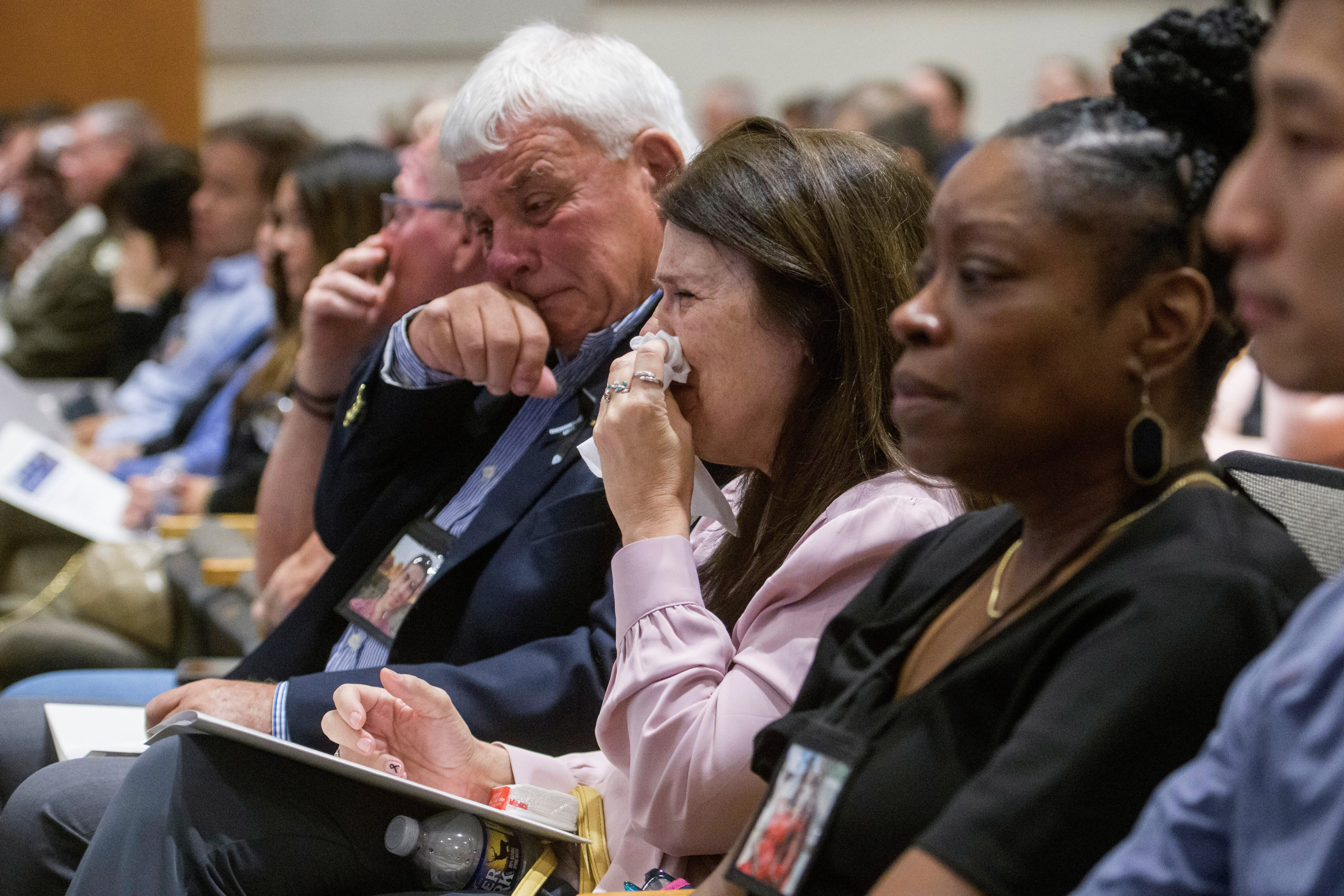Family members of the victims of American Airlines flight 5342 who perished in a collision with a U.S. military helicopter, react while watching a video of the moment of the crash