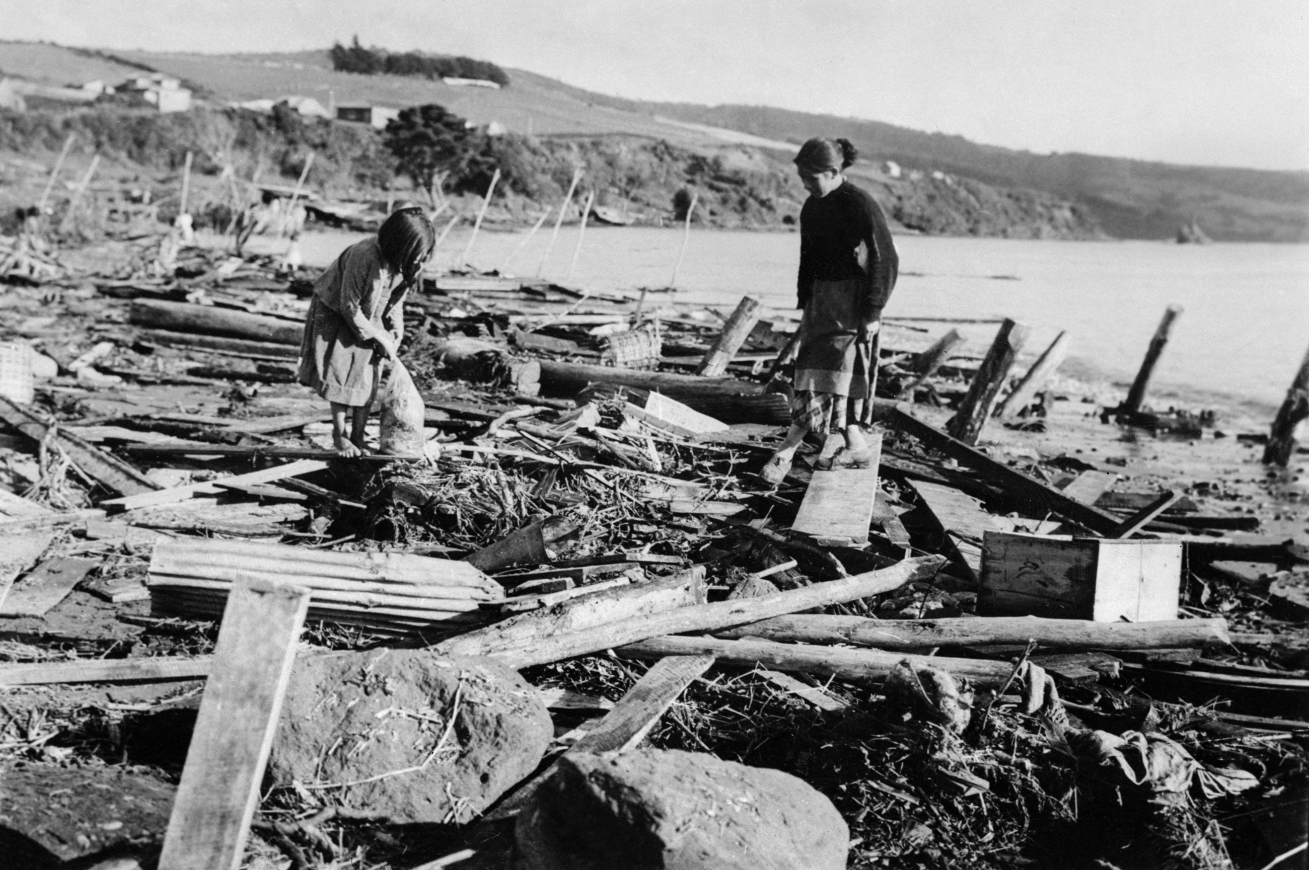 A little girl and her mother search for familiar objects 26 May 1960 in Puerto Montt, Chile, after the earthquake and the tidal waves that struck the area on May 22, 1960
