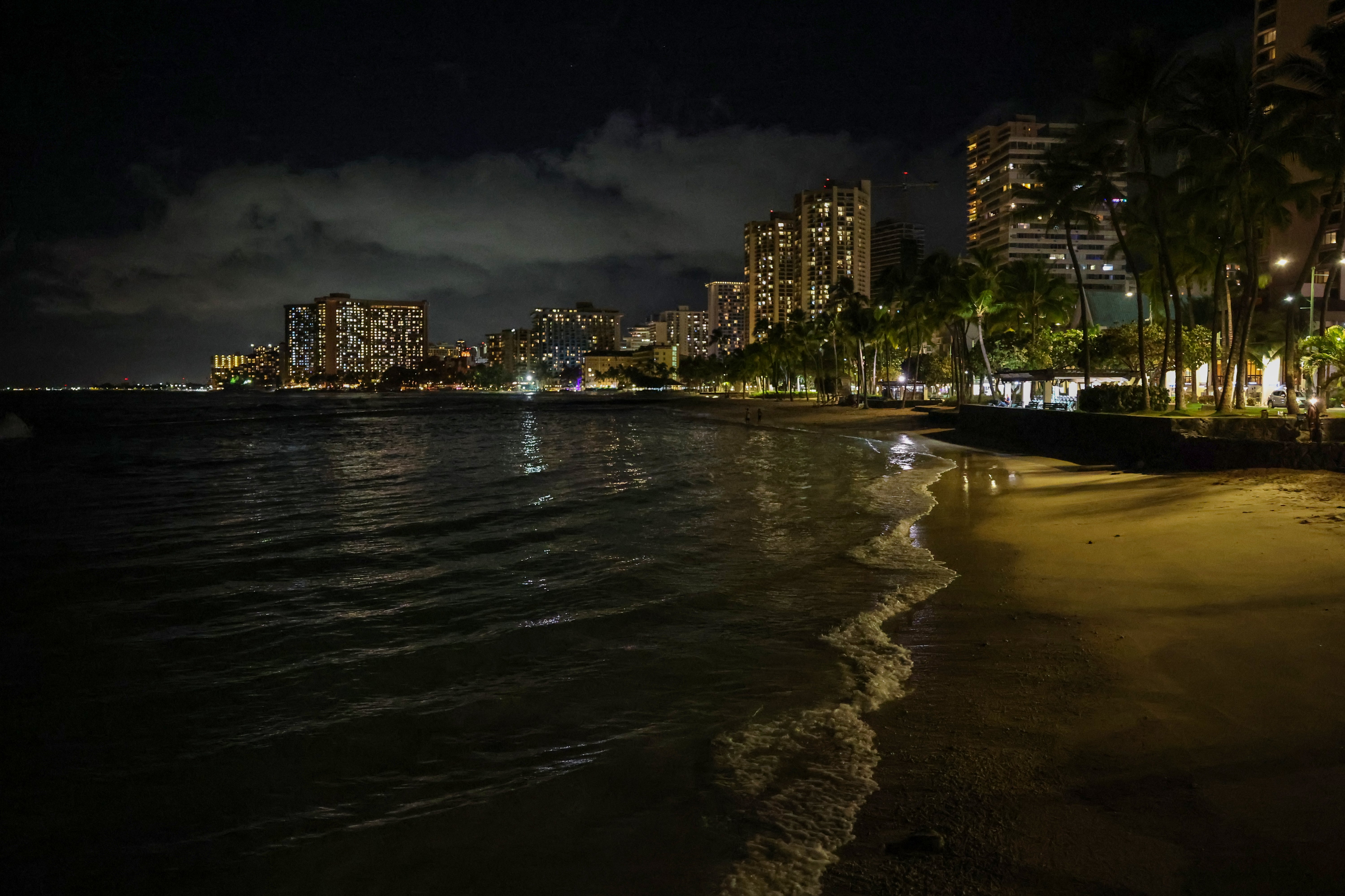 Waves roll on to an empty Waikiki Beach on Tuesday evening in Honolulu, Hawaii, with parts of Alaska and the U.S. West Coast under tsnumai warnings