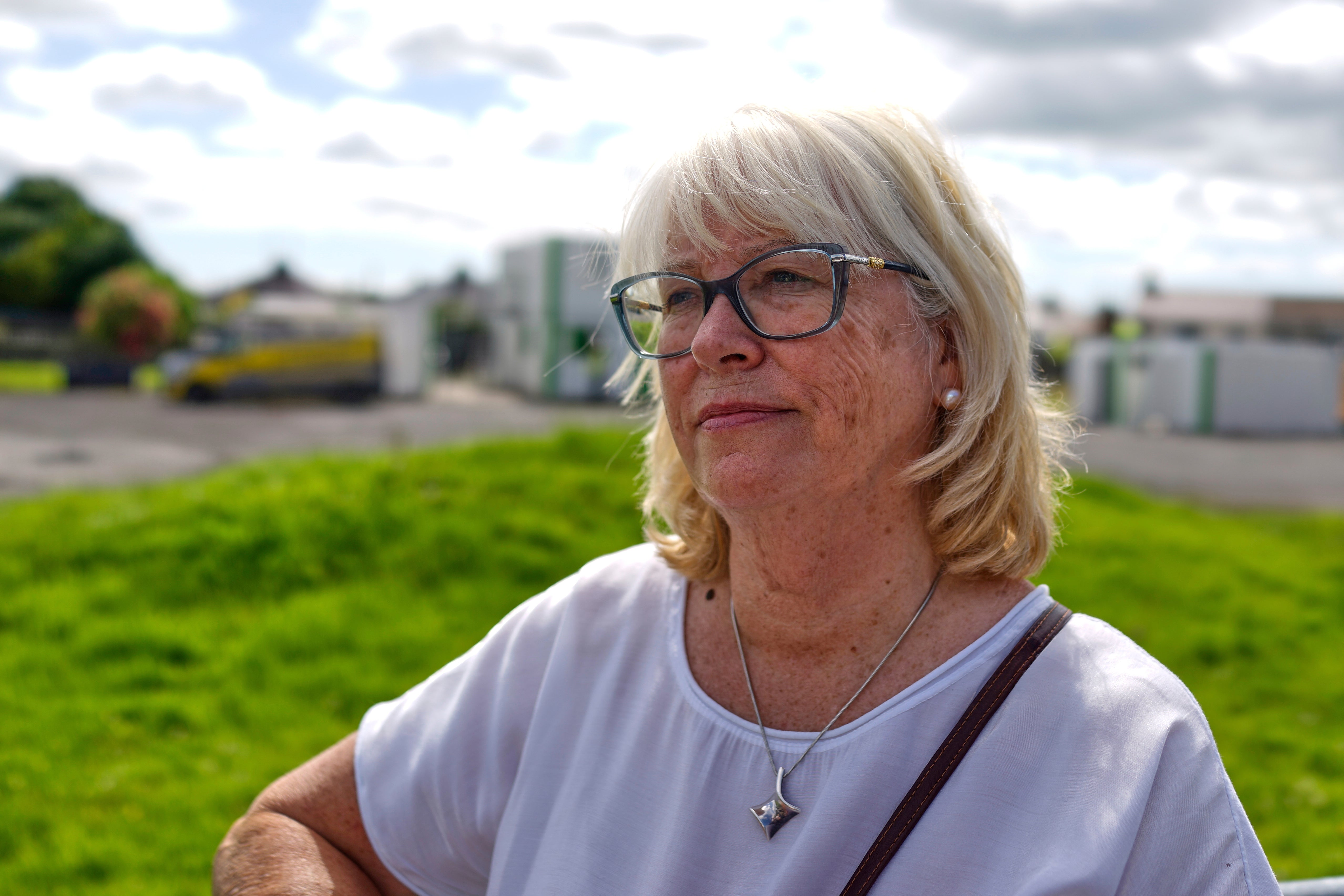Annette McKay, whose mother gave birth to a baby girl who died at the mother and baby home in Tuam, Ireland, stands next to the area where workers are excavating remains of up to nearly 800 children believed to be buried there, Tuesday, July 8, 2025. (AP Photo/Brian Melley)