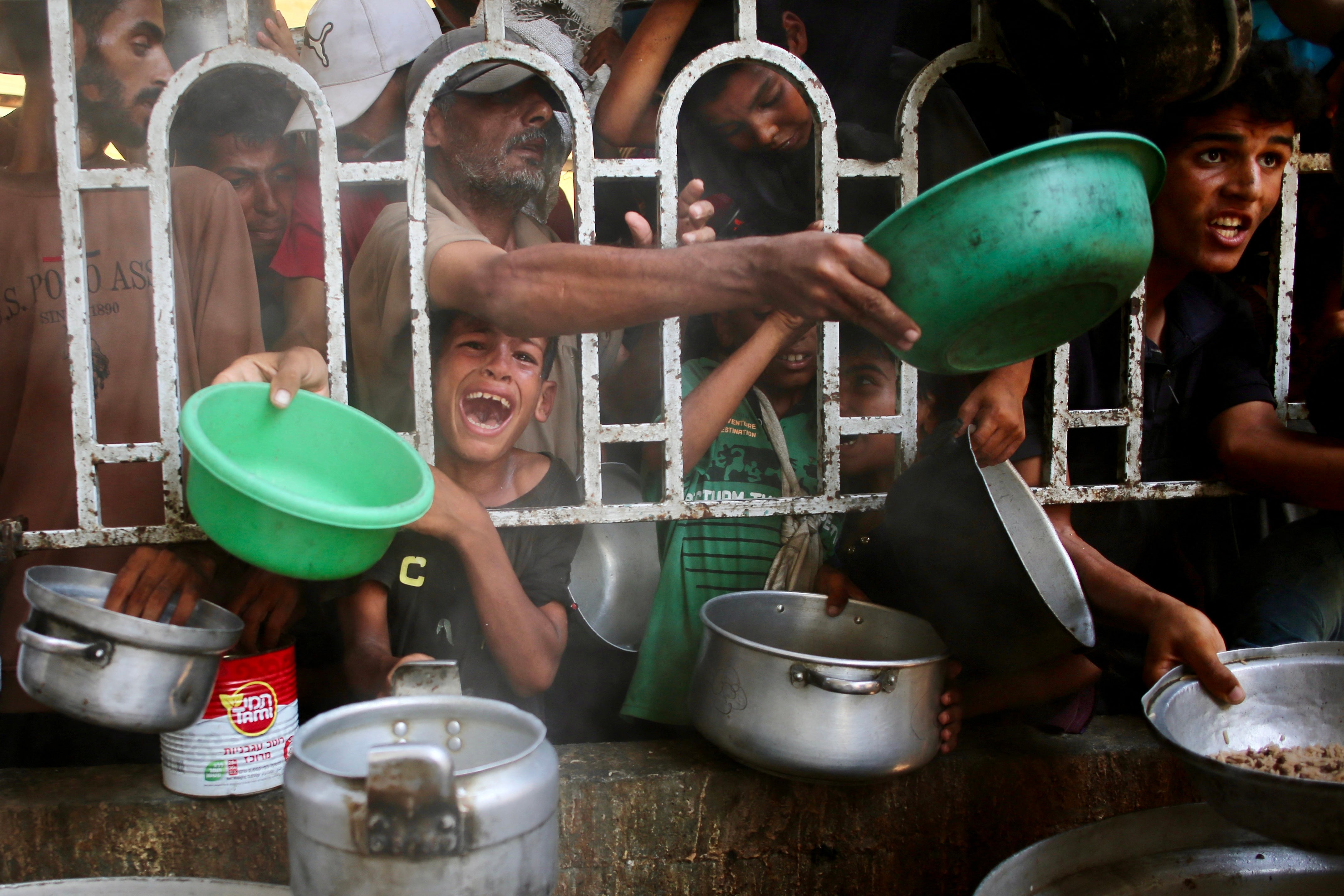 Starving Palestinians waiting to receive food from a charity last Tuesday