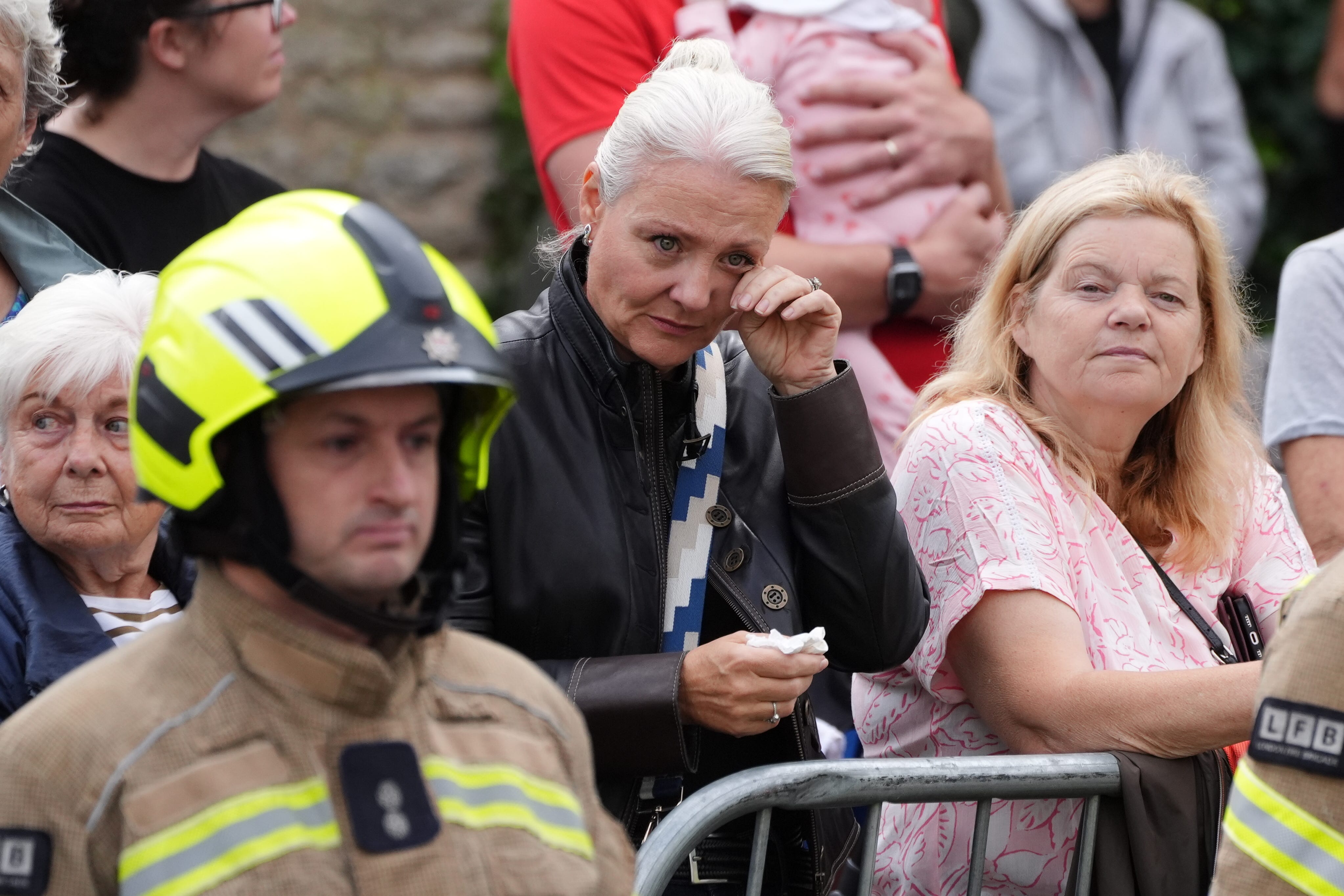 Firefighters and locals line the street as the funeral cortege passes Bicester Fire Station, Oxfordshire (Jonathan Brady/PA)