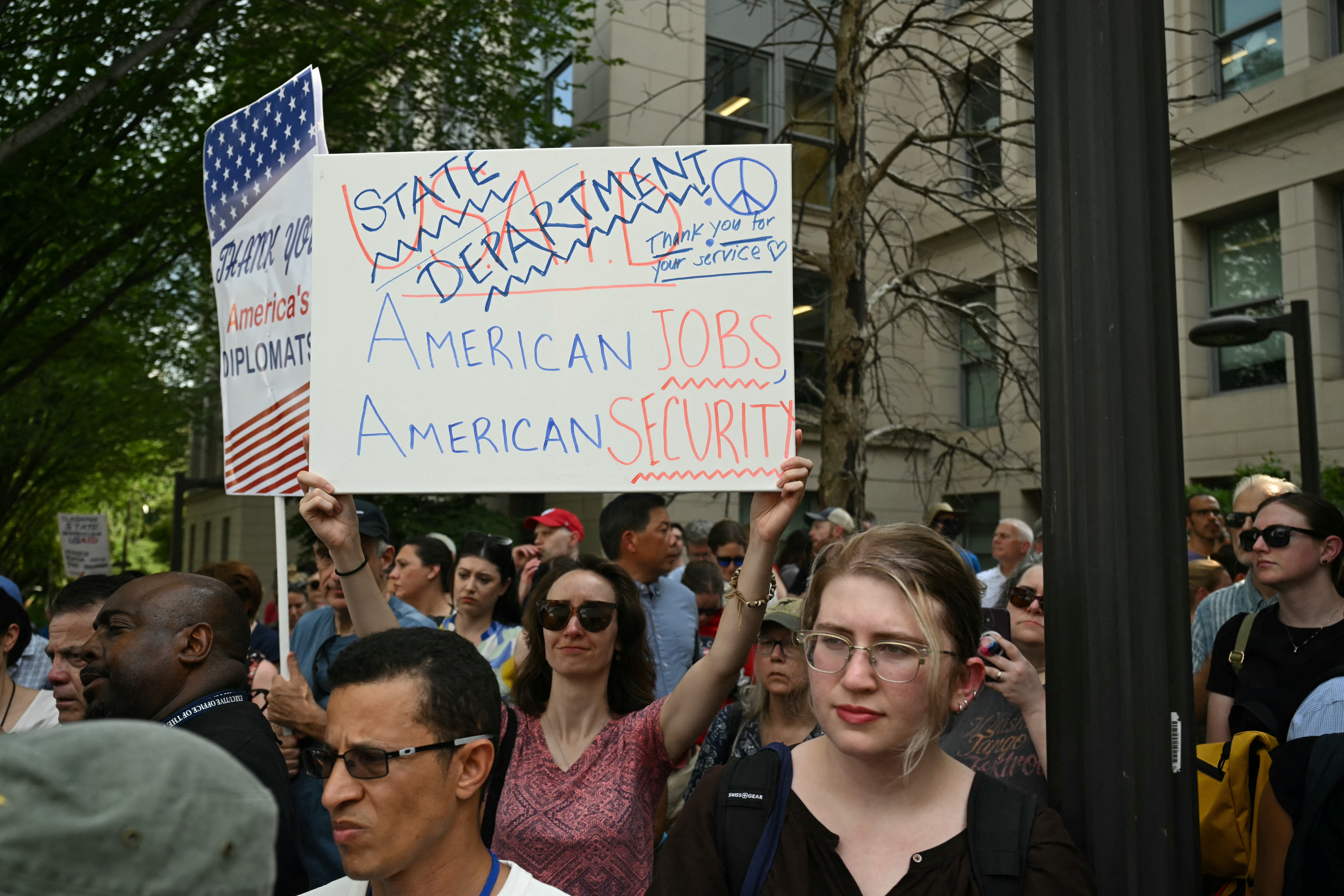 Supporters protest outside the State Department after the agency laid off workers