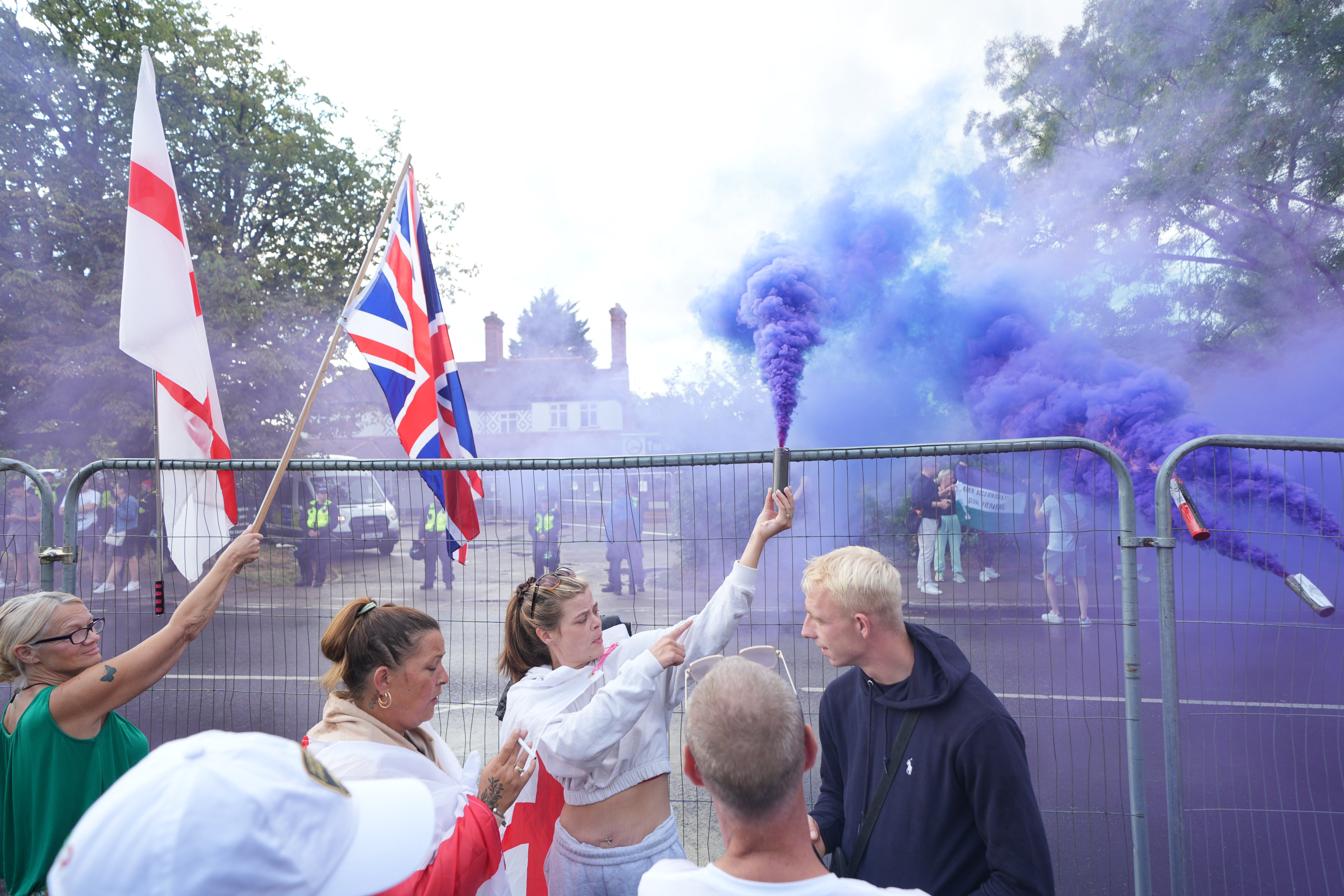 Protesters stand outside Bell Hotel in Epping, Essex, after an asylum seeker was charged with sexually assaulting a 14-year-old girl