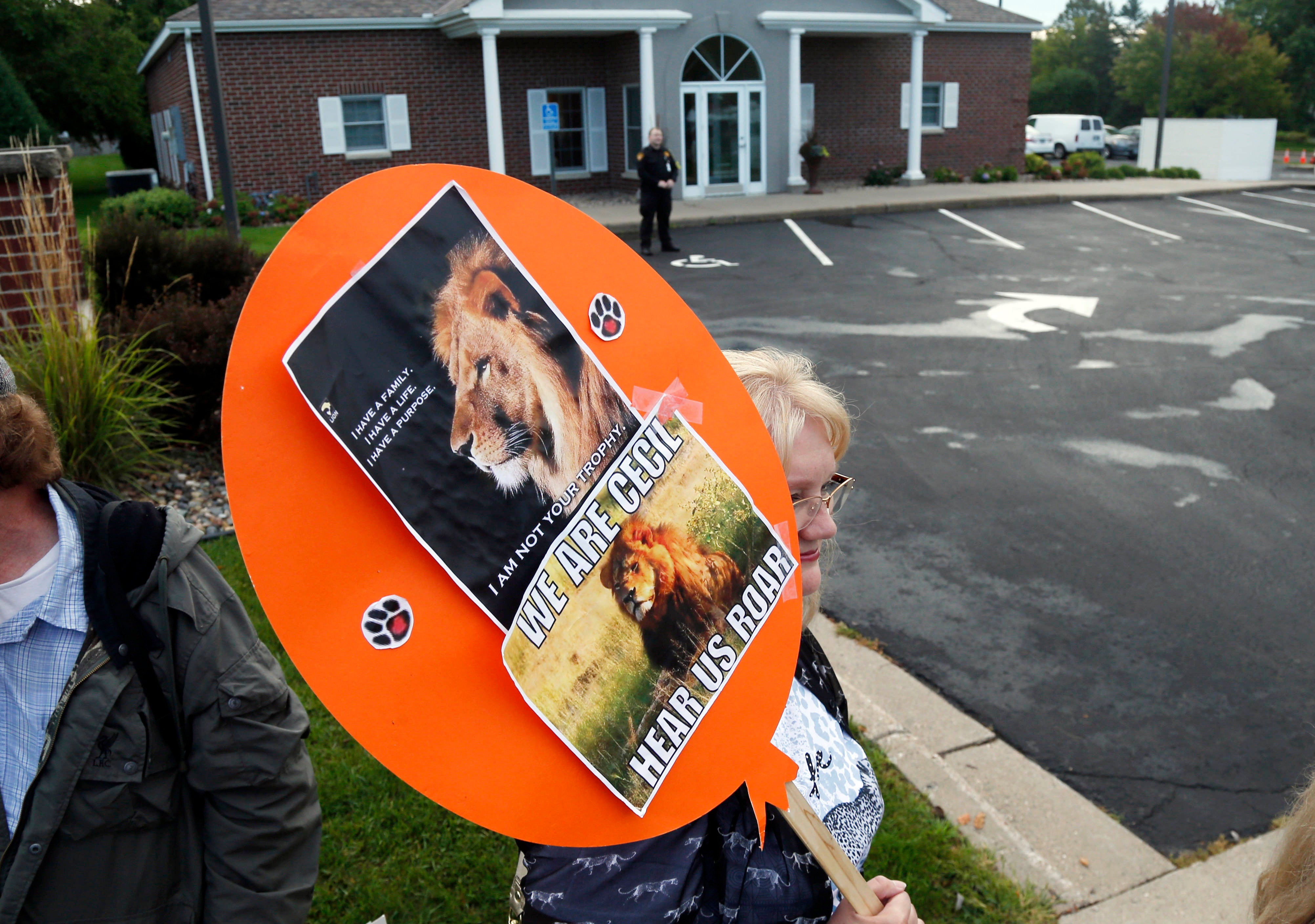 Demonstrators gather outside the dental practice of Walter Palmer, Sept. 8, 2015, in Bloomington, Minn. AP Photo/Jim Mone, File)