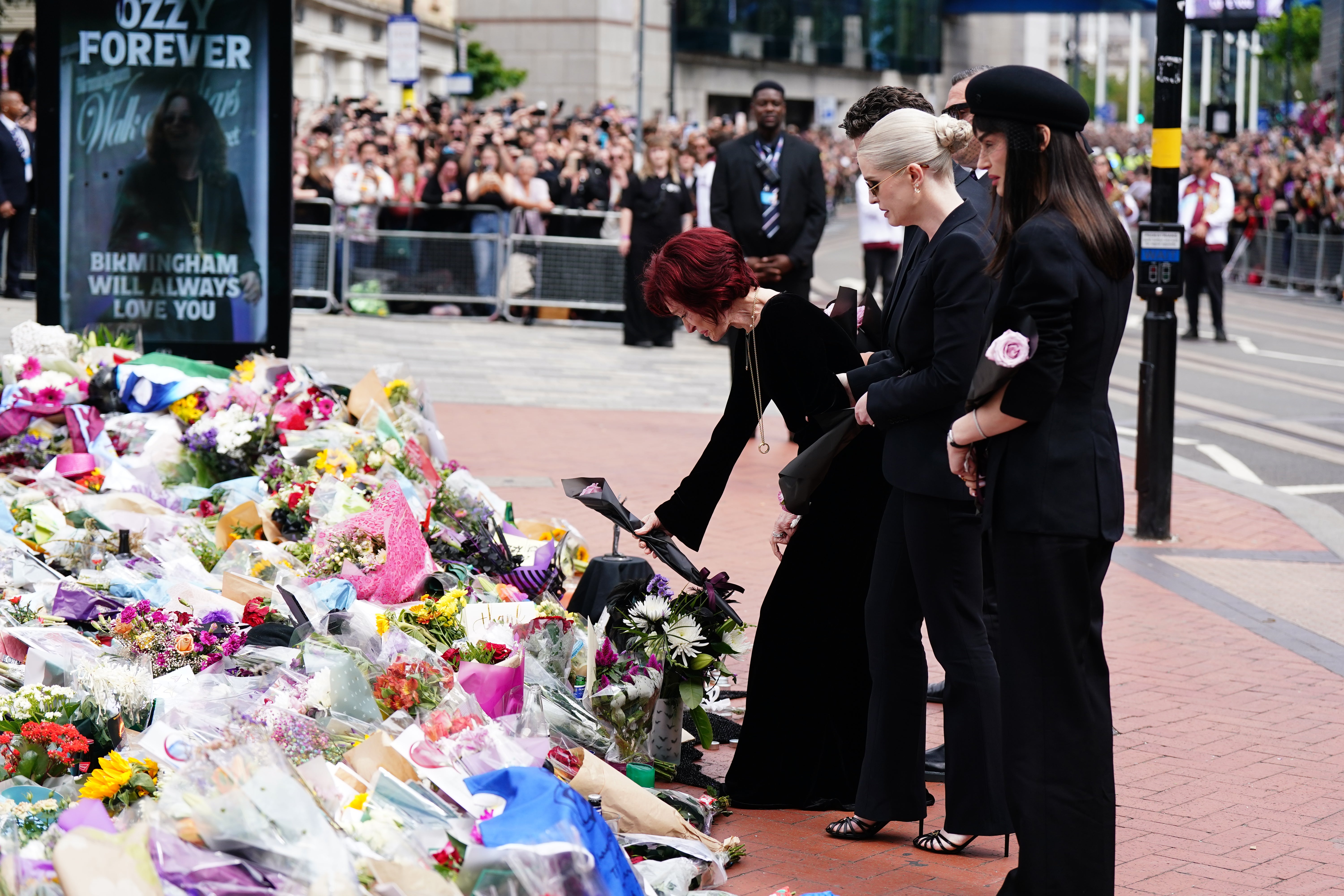Sharon Osbourne, with children Jack, Kelly and Aimee, lays flowers at the Black Sabbath Bridge bench on Broad Street in Birmingham in memory of Ozzy Osbourne