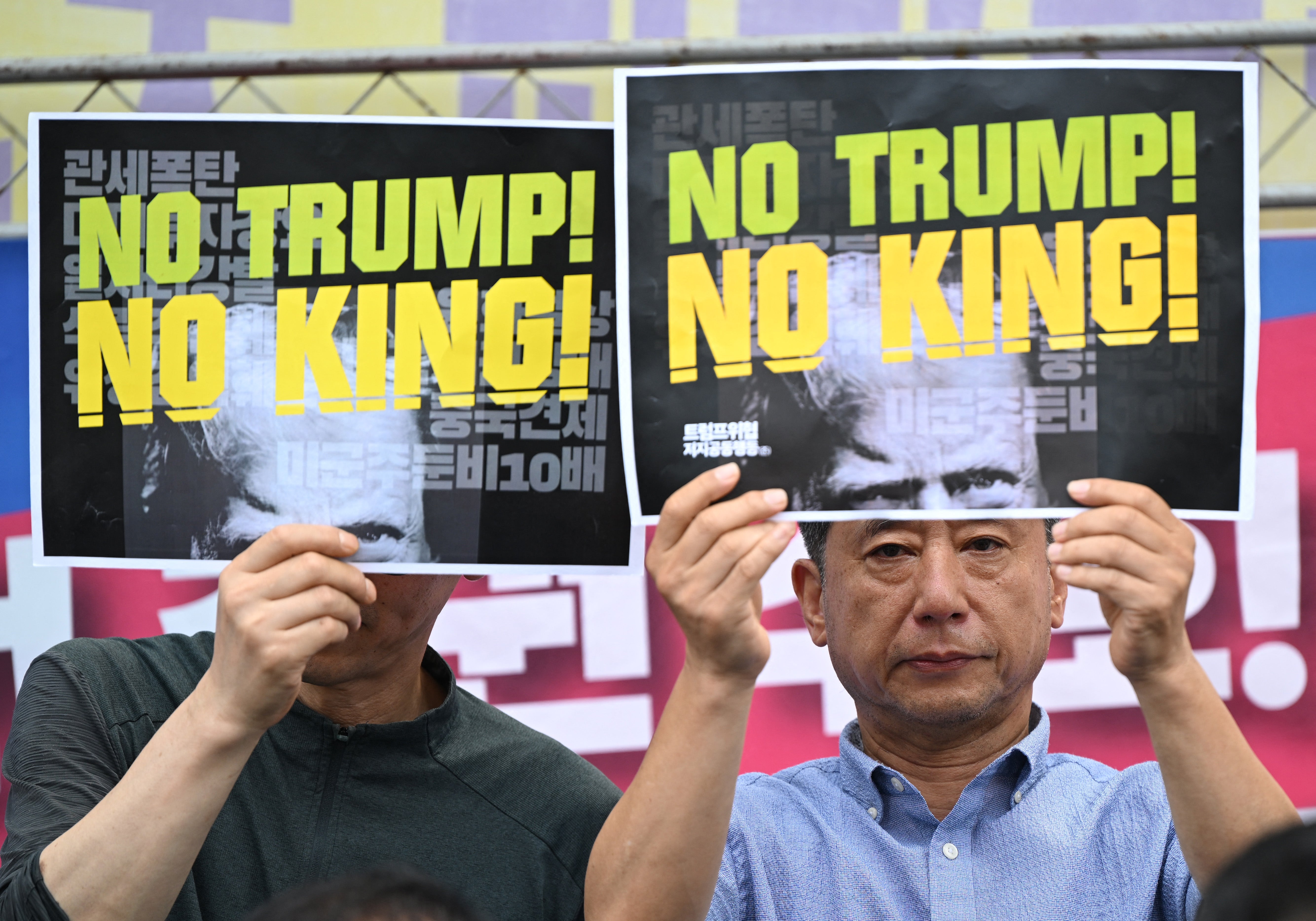 South Korean protesters hold signs during a rally against Donald Trump's tariff policy near the US embassy in Seoul