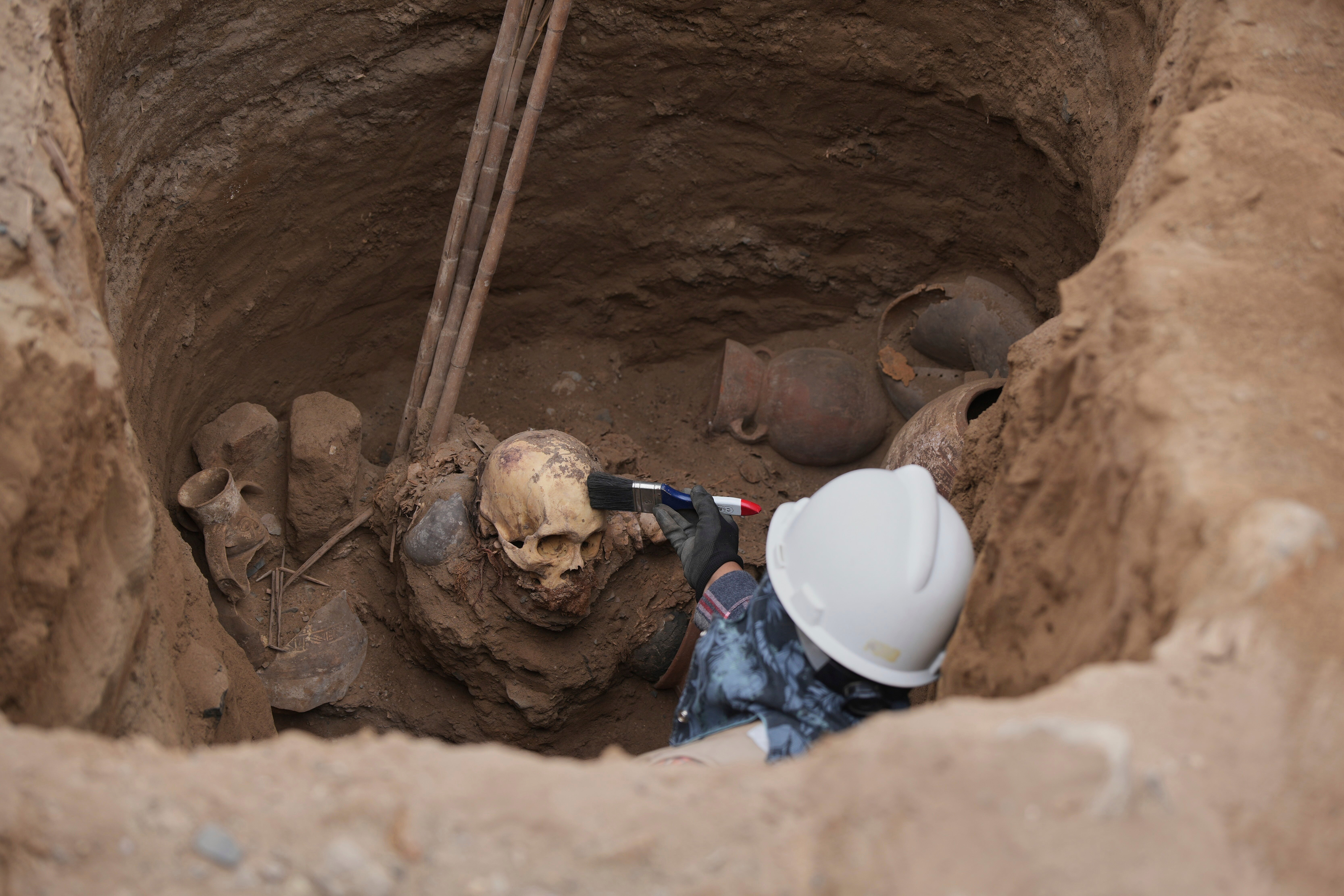 Archaeologist Jose Aliaga works at the site where city workers discovered ancient remains, from the pre-Inca Chancay culture, and artifacts as workers were digging a natural gas line for the company Calidda in the district of Puente Piedra on the outskirts of Lima, Peru