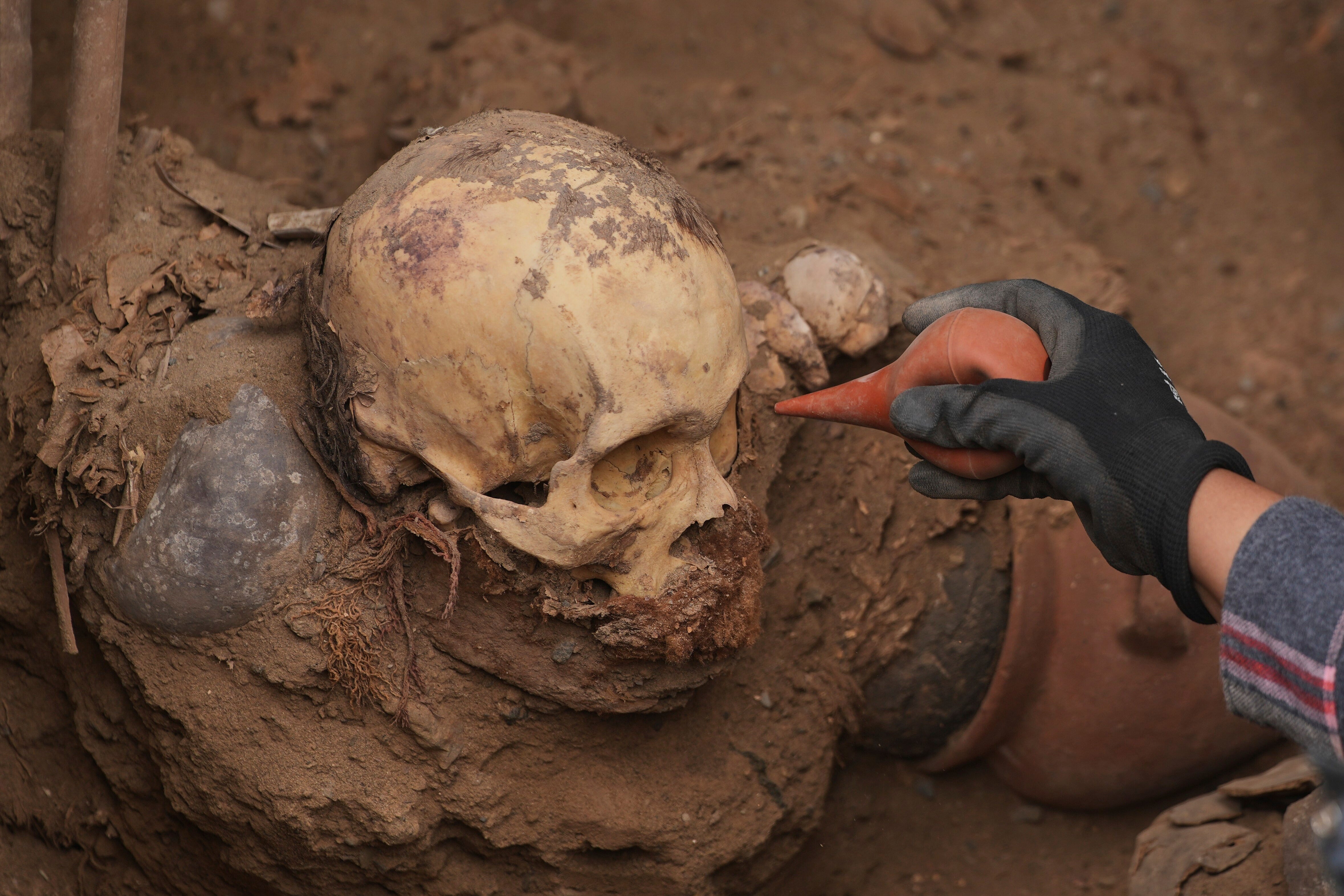 Archaeologist Jose Aliaga works at the site where city workers discovered ancient remains, from the pre-Inca Chancay culture, and artifacts as they were digging a natural gas line on the outskirts of Lima, Peru