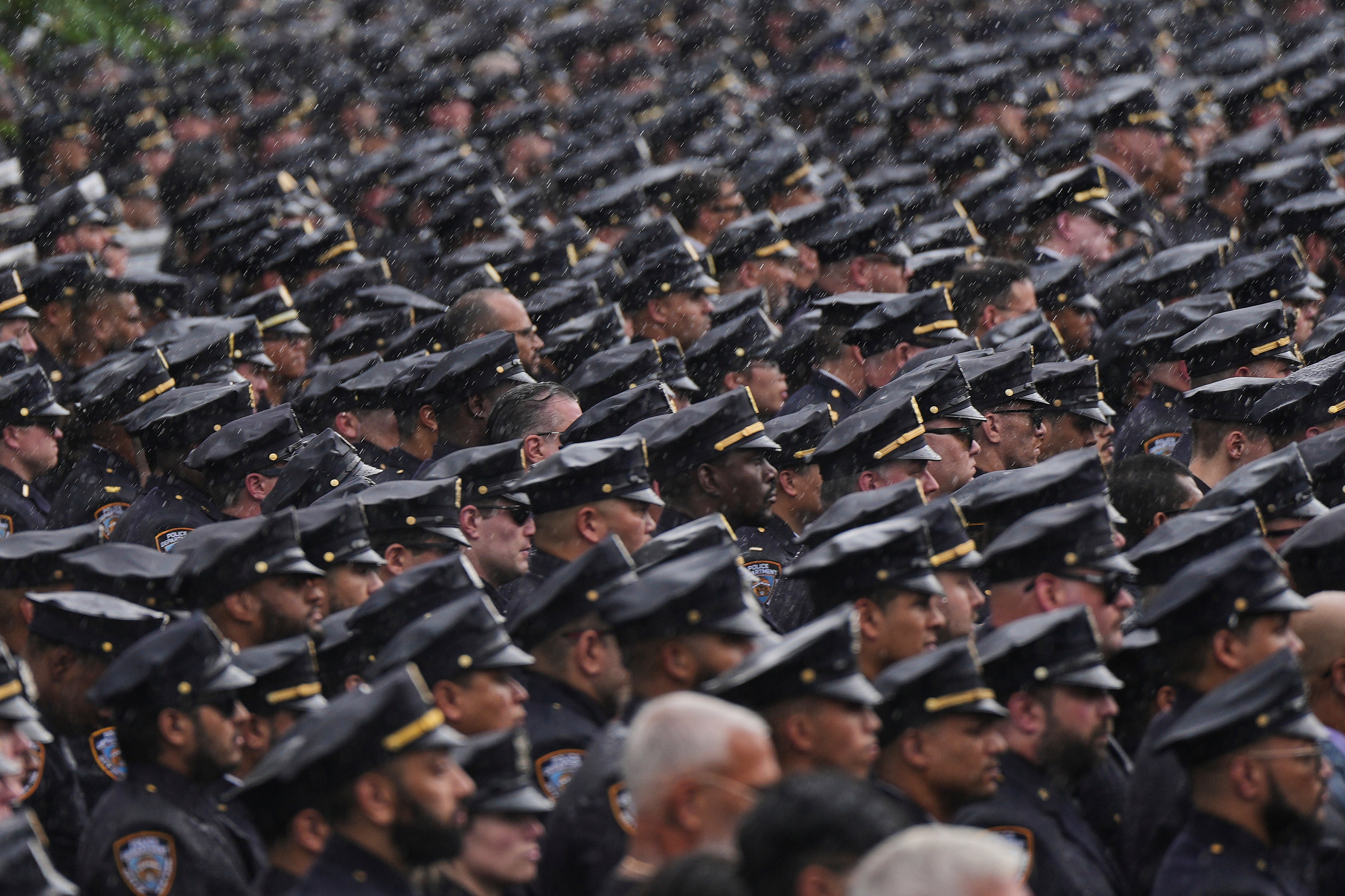 NYPD officers stand to attention as the hearse carrying the casket of officer Didarul Islam passes