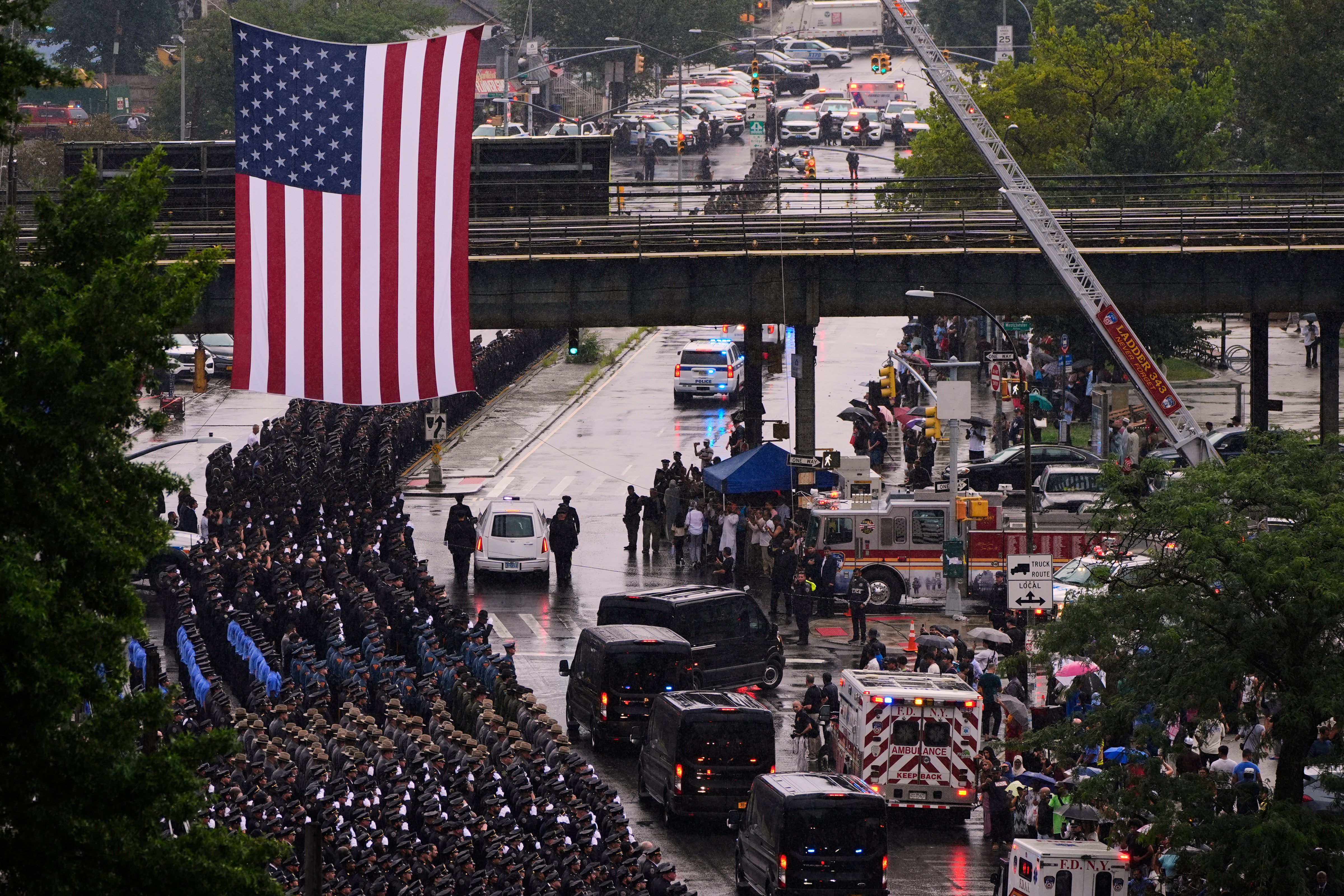 The hearse carrying the casket of NYPD officer Didarul Islam is escorted down White Plains road after his funeral
