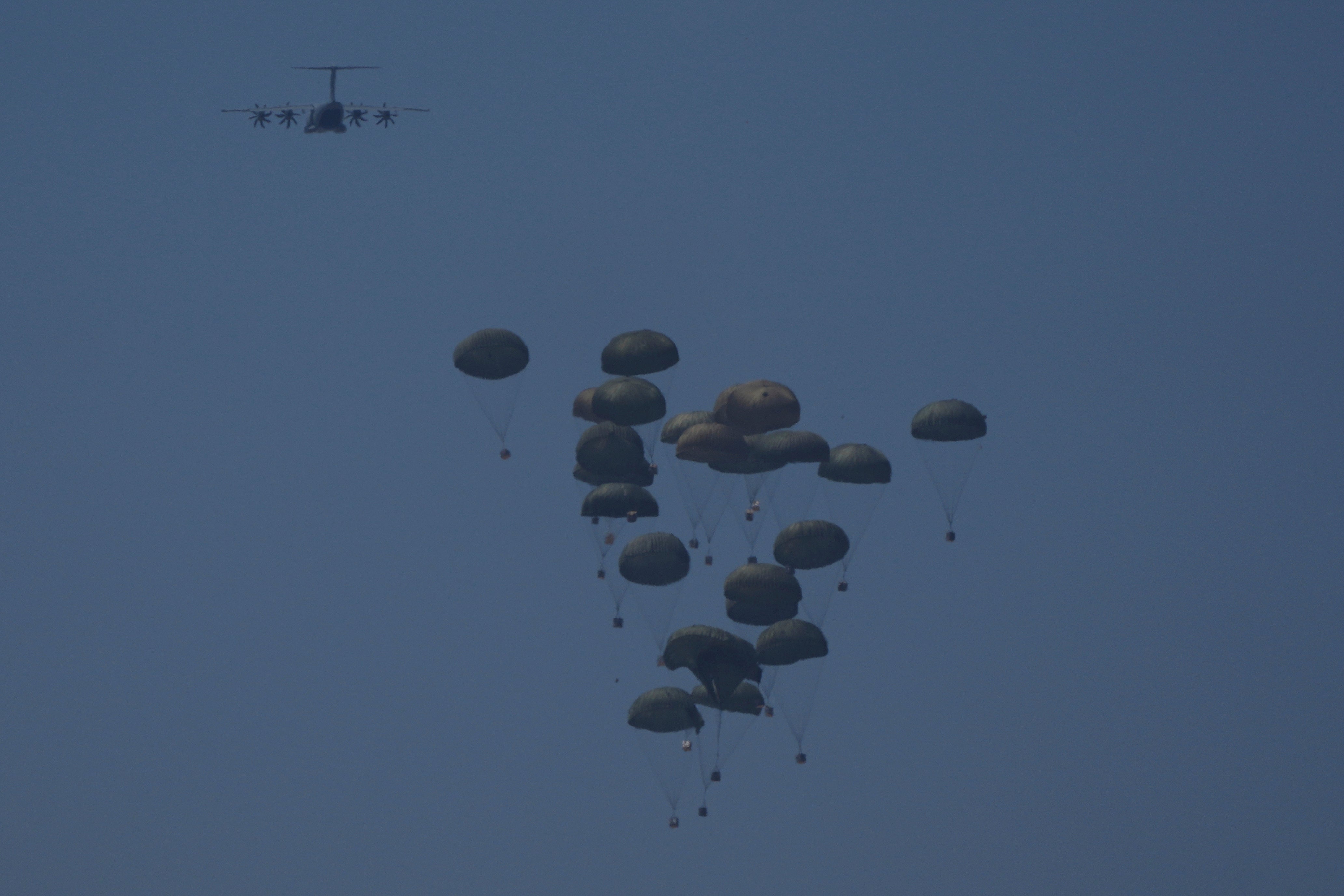 An aircraft airdrops humanitarian aid to Palestinians over Khan Younis, in the Gaza Strip