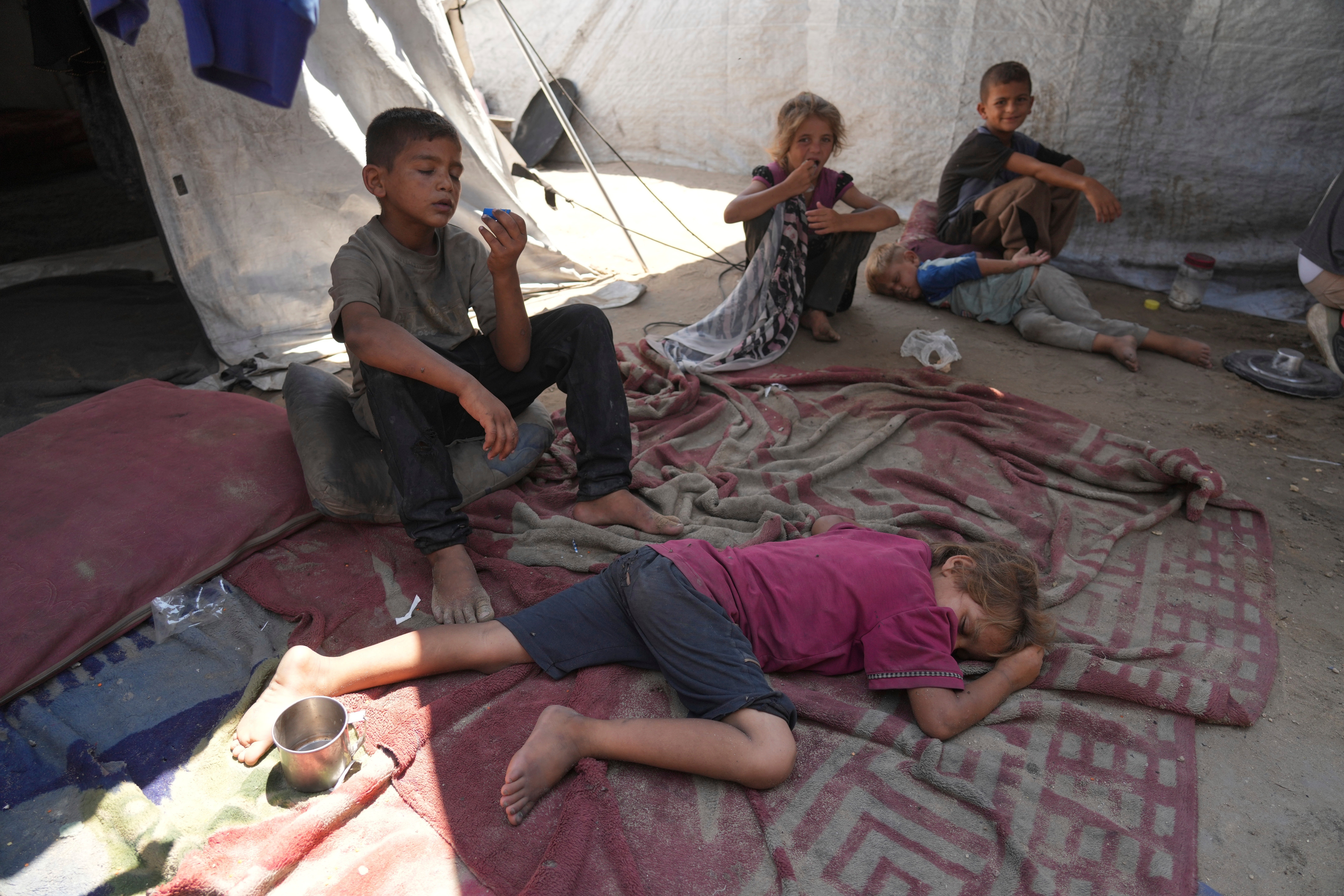 Children from the Sobh family rest inside their tent at a camp for displaced Palestinians in Gaza City, in July