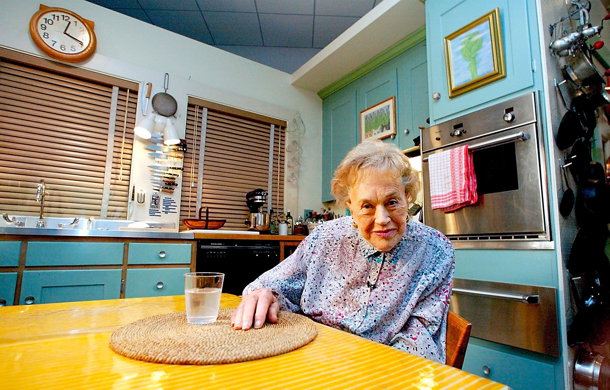 Julia Child sits in her kitchen after being moved and rebuilt from her Cambridge, MA home on 19 August 2002 as part of an exhibit at the National Museum of American History in Washington, DC