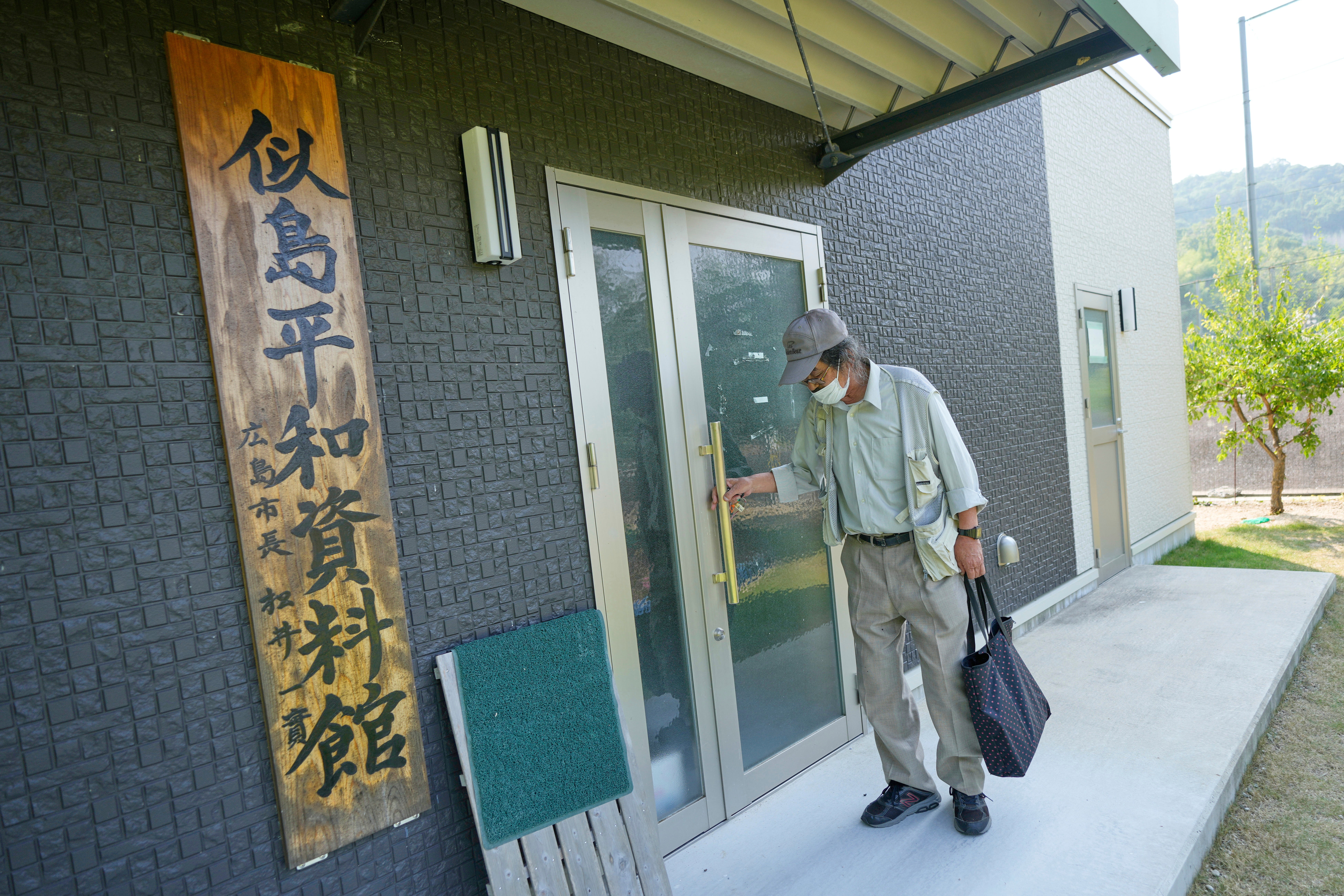 Kazuo Miyazaki, a local historian and head of the Ninoshima History Volunteer Guide Association, opens his peace information center