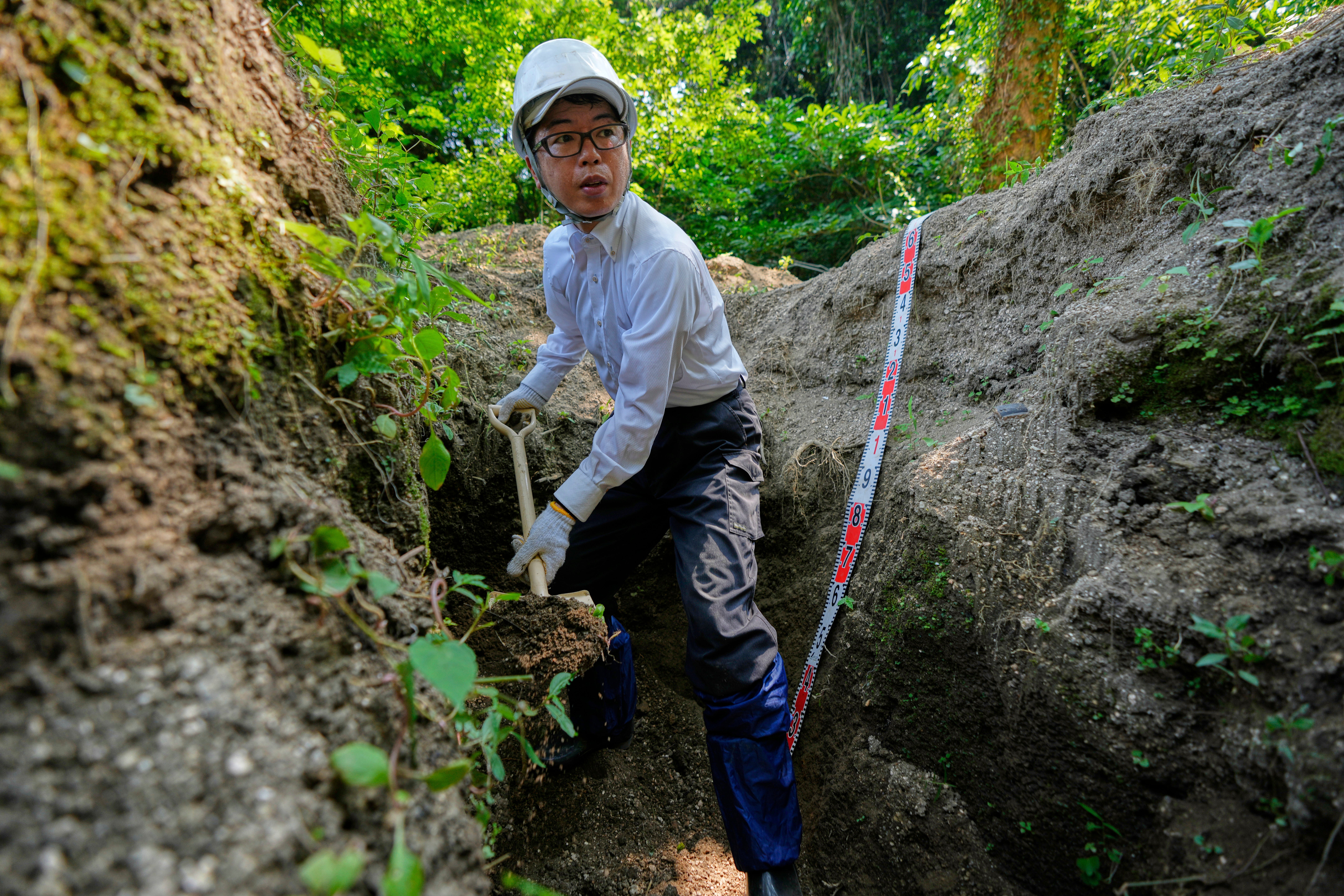 Rebun Kayo, a Hiroshima University researcher, searches for remains of victims of the 1945 Hiroshima bombing in Ninoshima in Hiroshima, western Japan