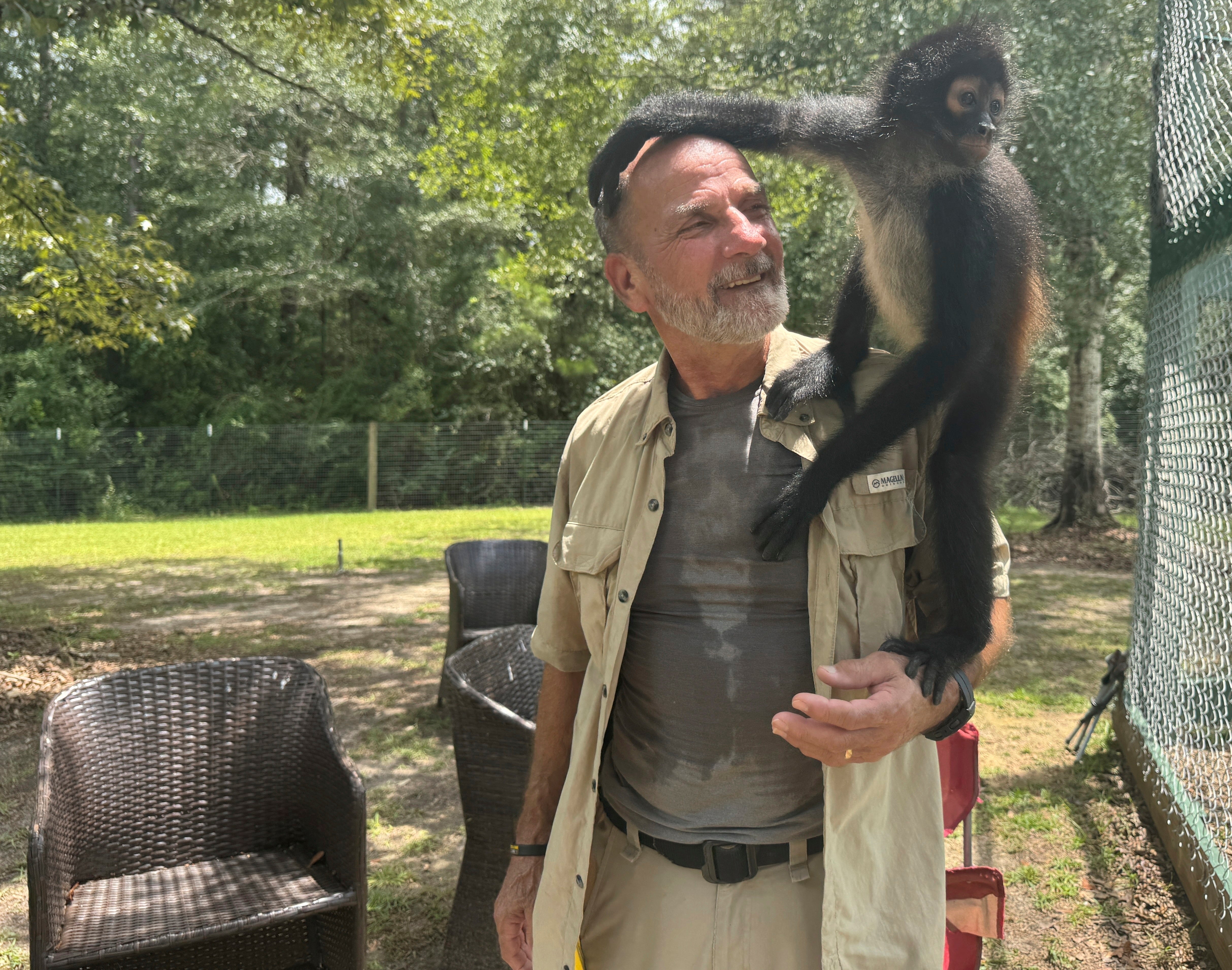 Louie the spider monkey climbs on John Richard, a volunteer at the Gulf Coast Primate Sanctuary in Perkinston, Mississippi