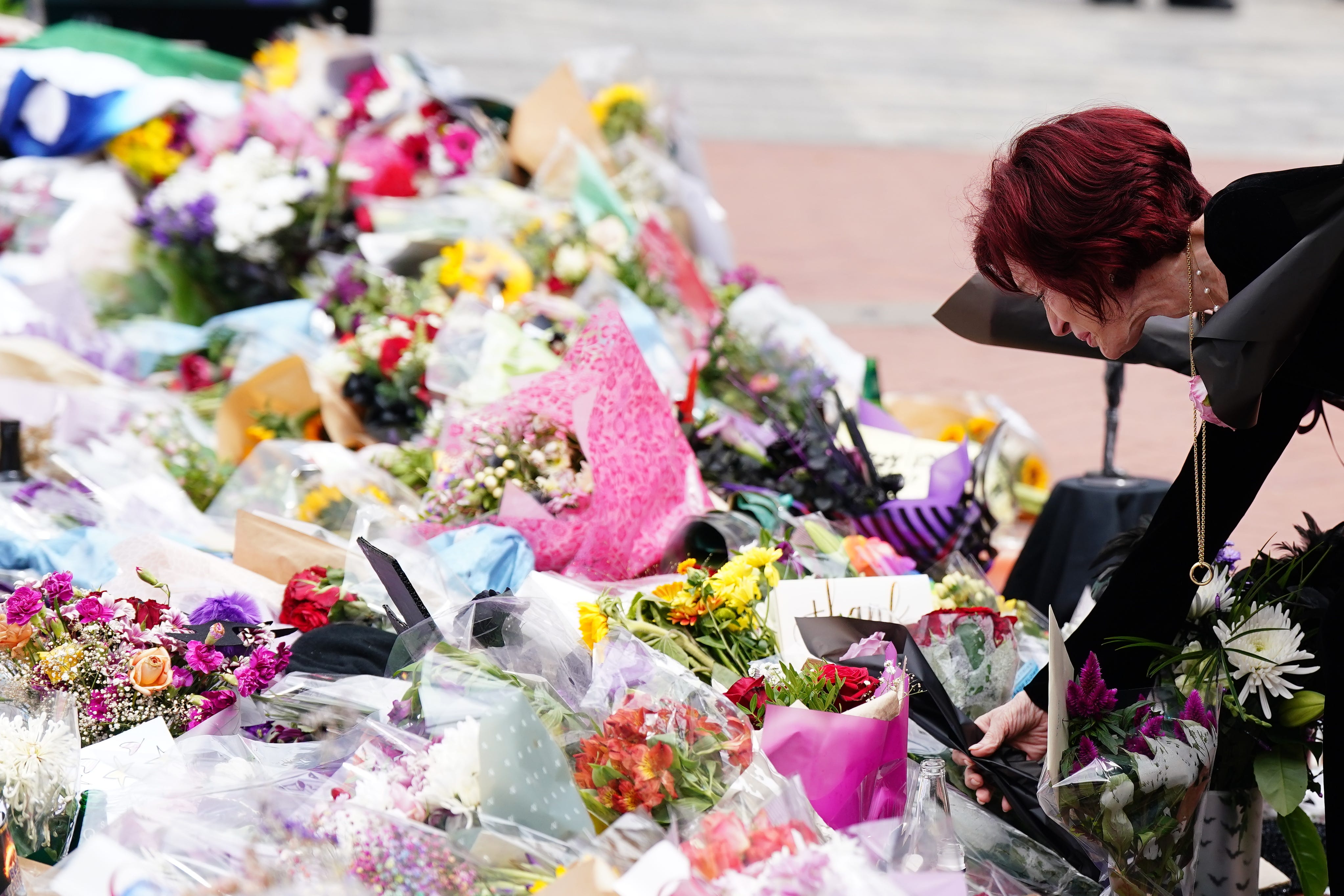 Sharon Osbourne lays flowers at the Black Sabbath Bridge bench on Broad Street in Birmingham in memory of her husband (Jacob King/PA)
