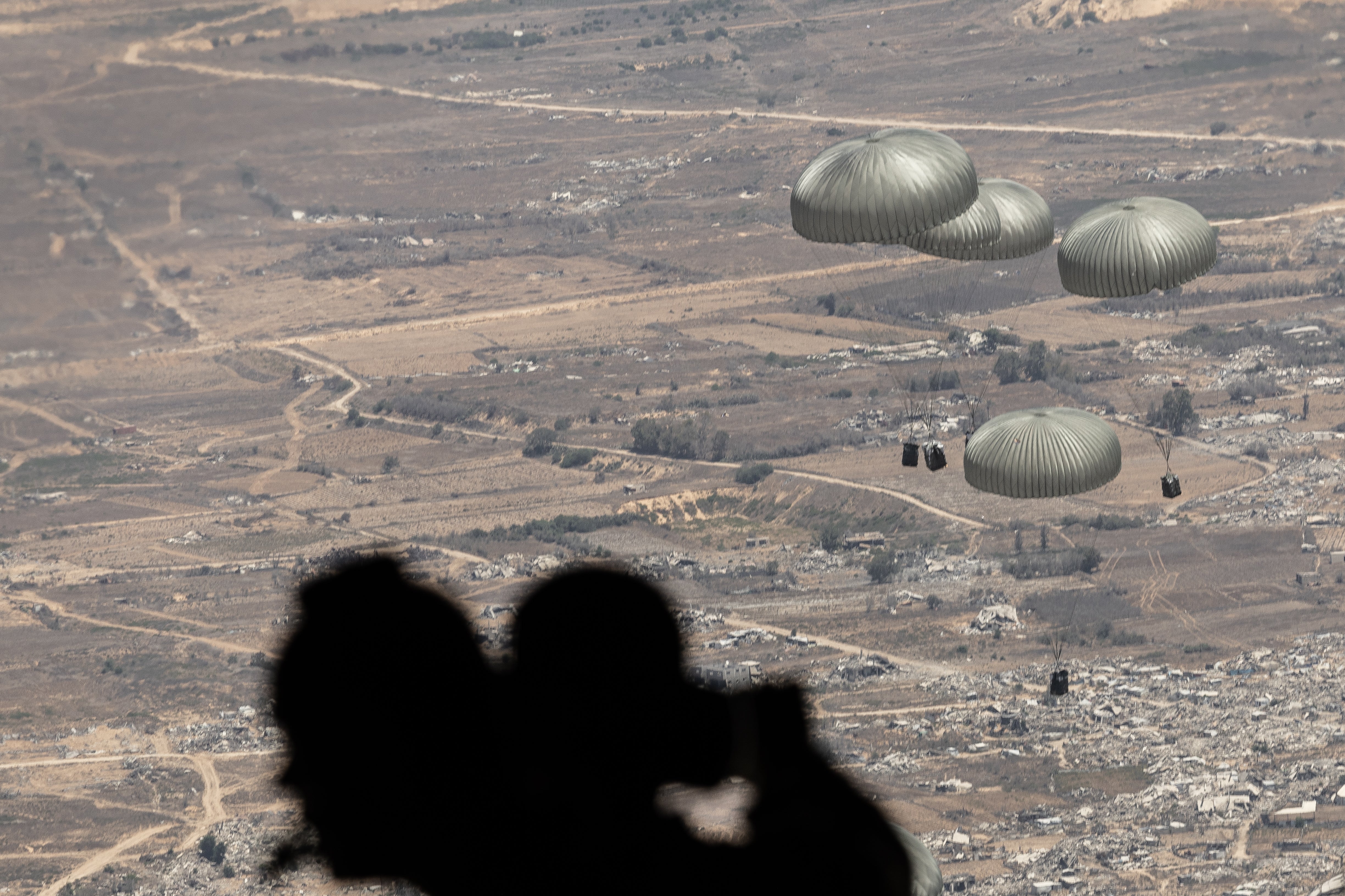 One-tonne pallets of aid float down into Gaza after being released by the Jordanian military