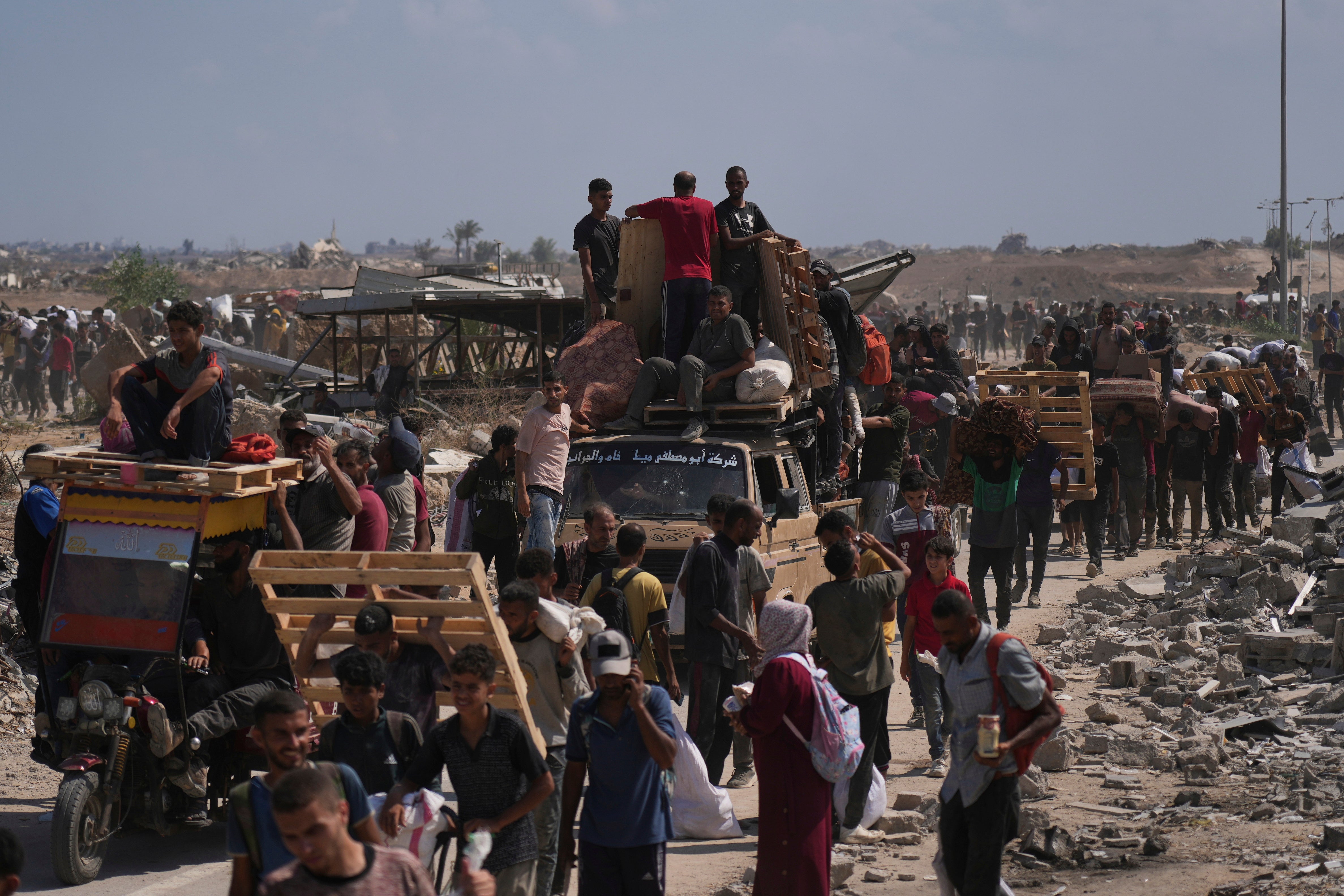 Palestinians carry humanitarian aid packages near a Gaza Humanitarian Foundation distribution center operated by the U.S.-backed organization, in Netzarim, central Gaza Strip