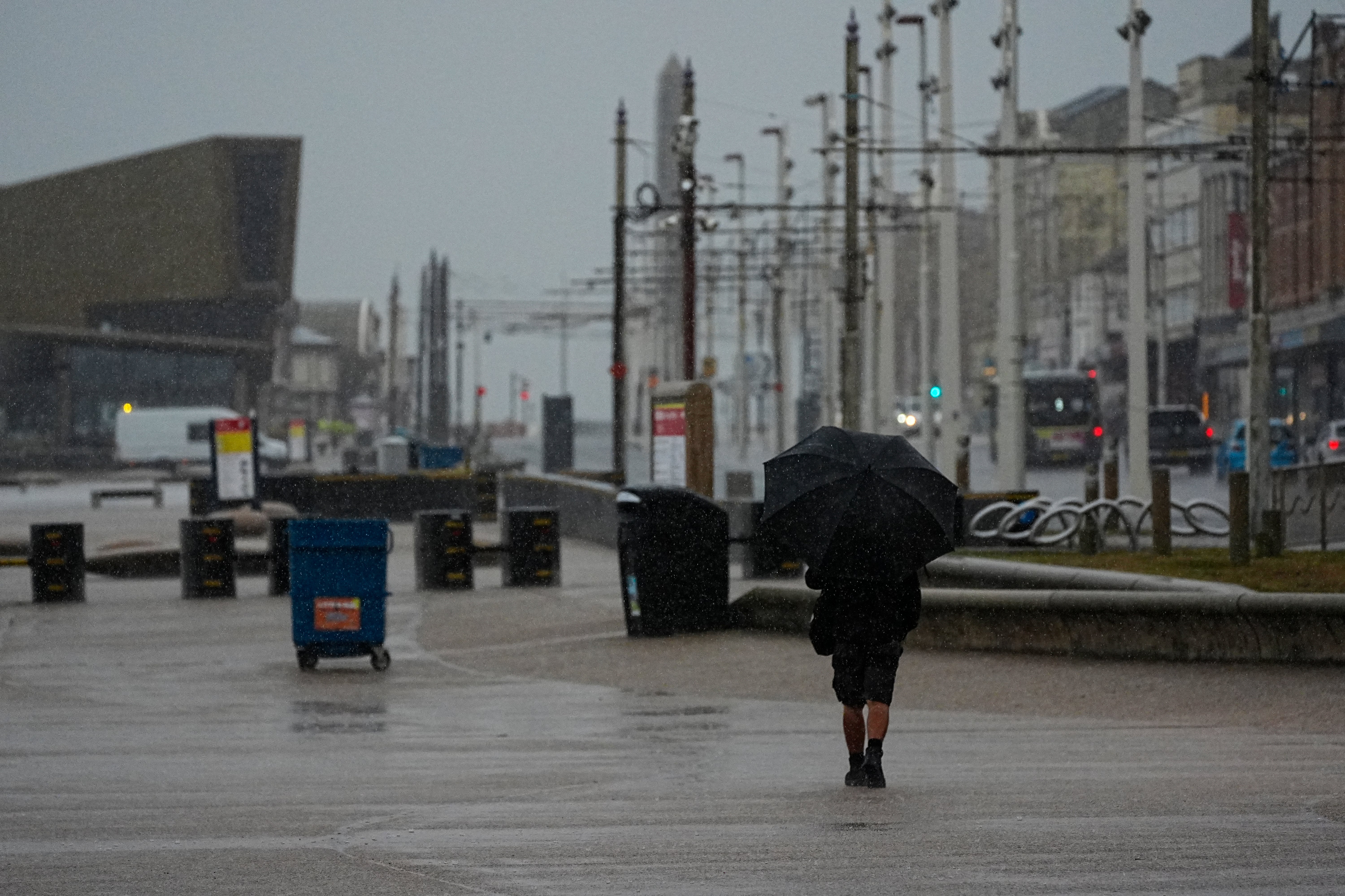 A woman walking along the seafront in Blackpool amid heavy winds and rain